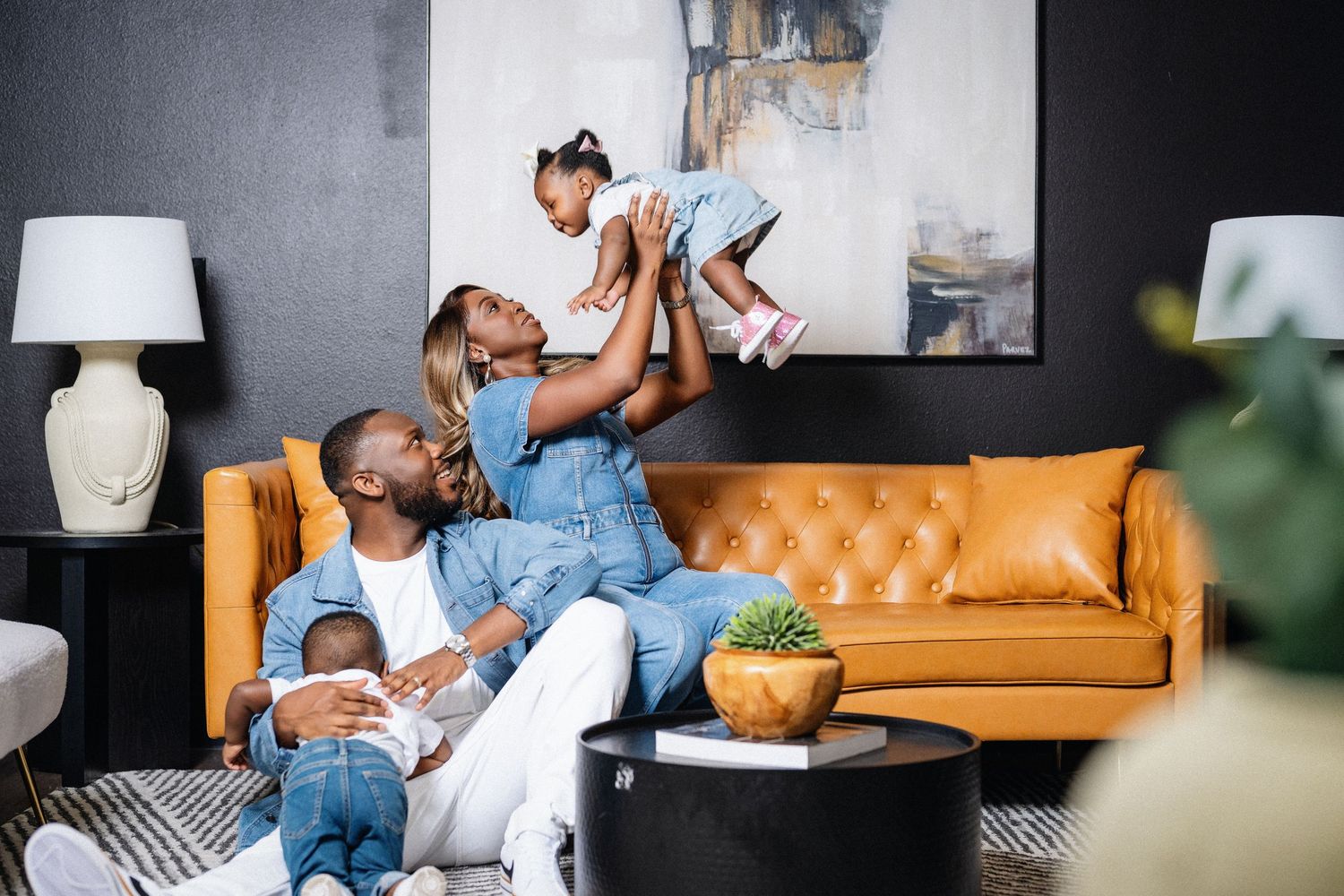 Parent and child share tender moments while relaxing together on orange couch at home.