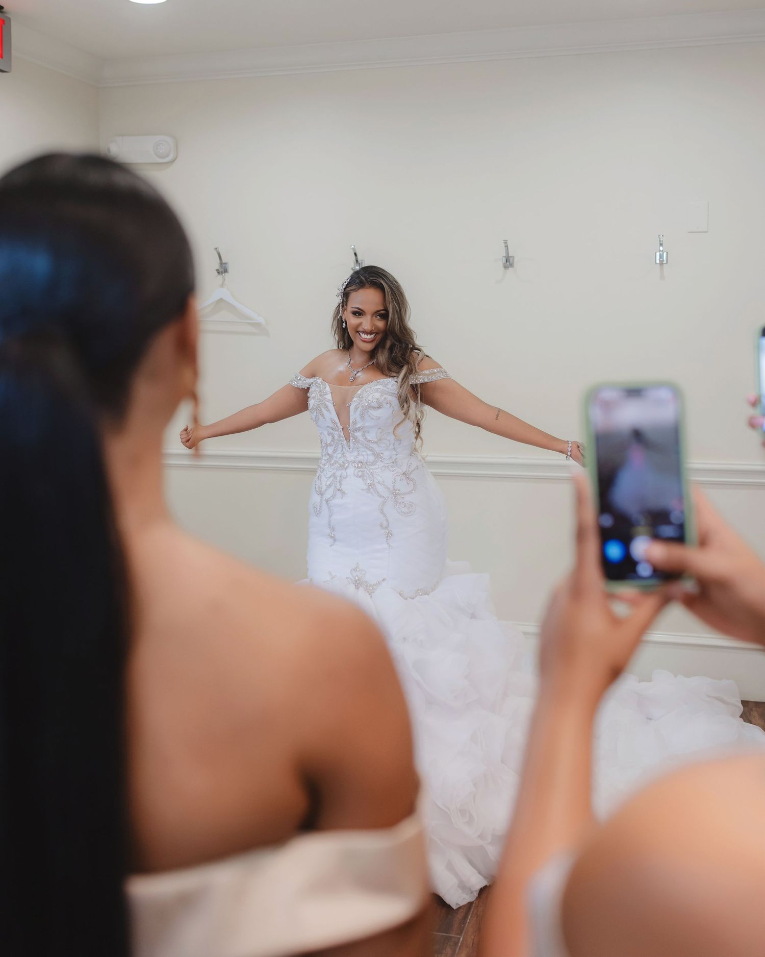A flowing white wedding dress being photographed during a bridal fitting session.