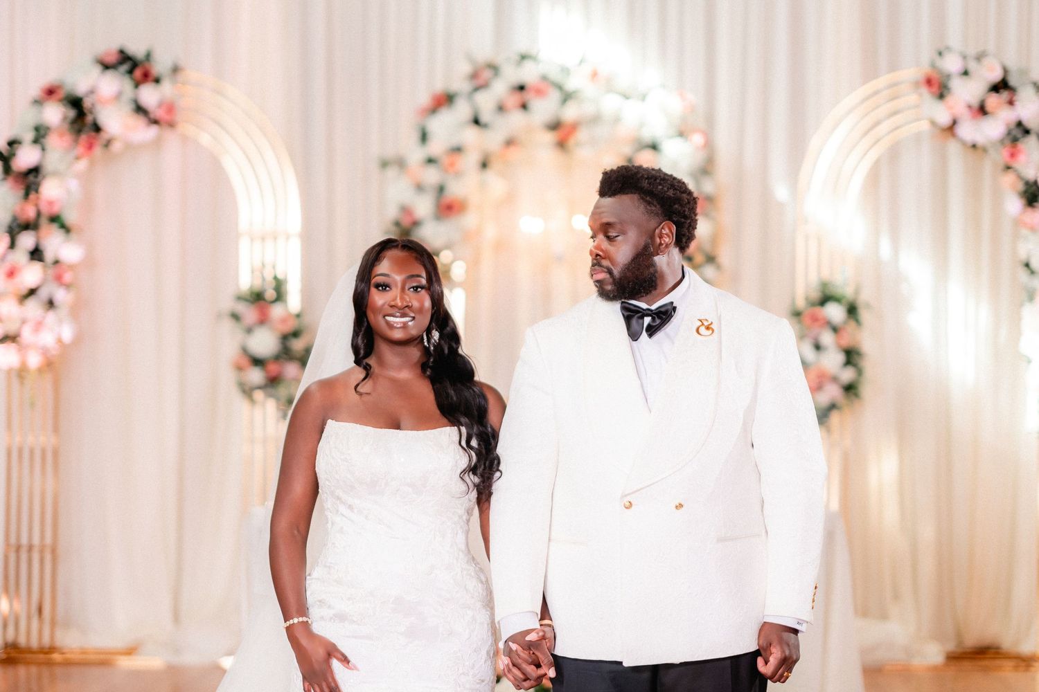 Elegant wedding ceremony setup with white decor and pink floral arrangements creating a romantic atmosphere.