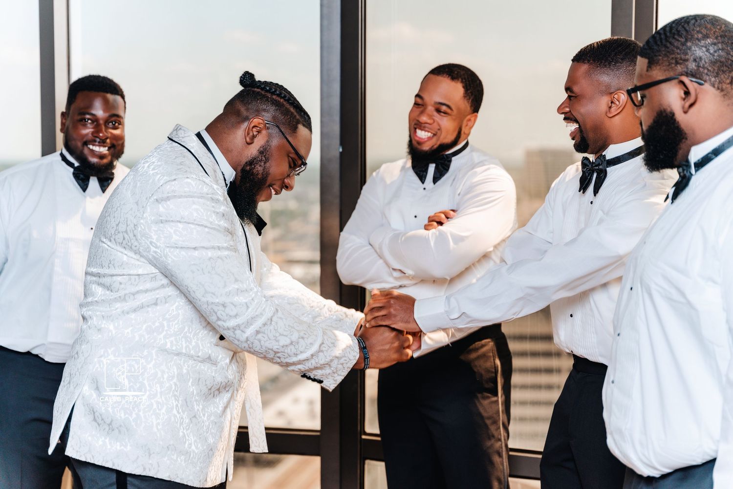 Groomsmen in white tuxedos sharing celebratory moments.