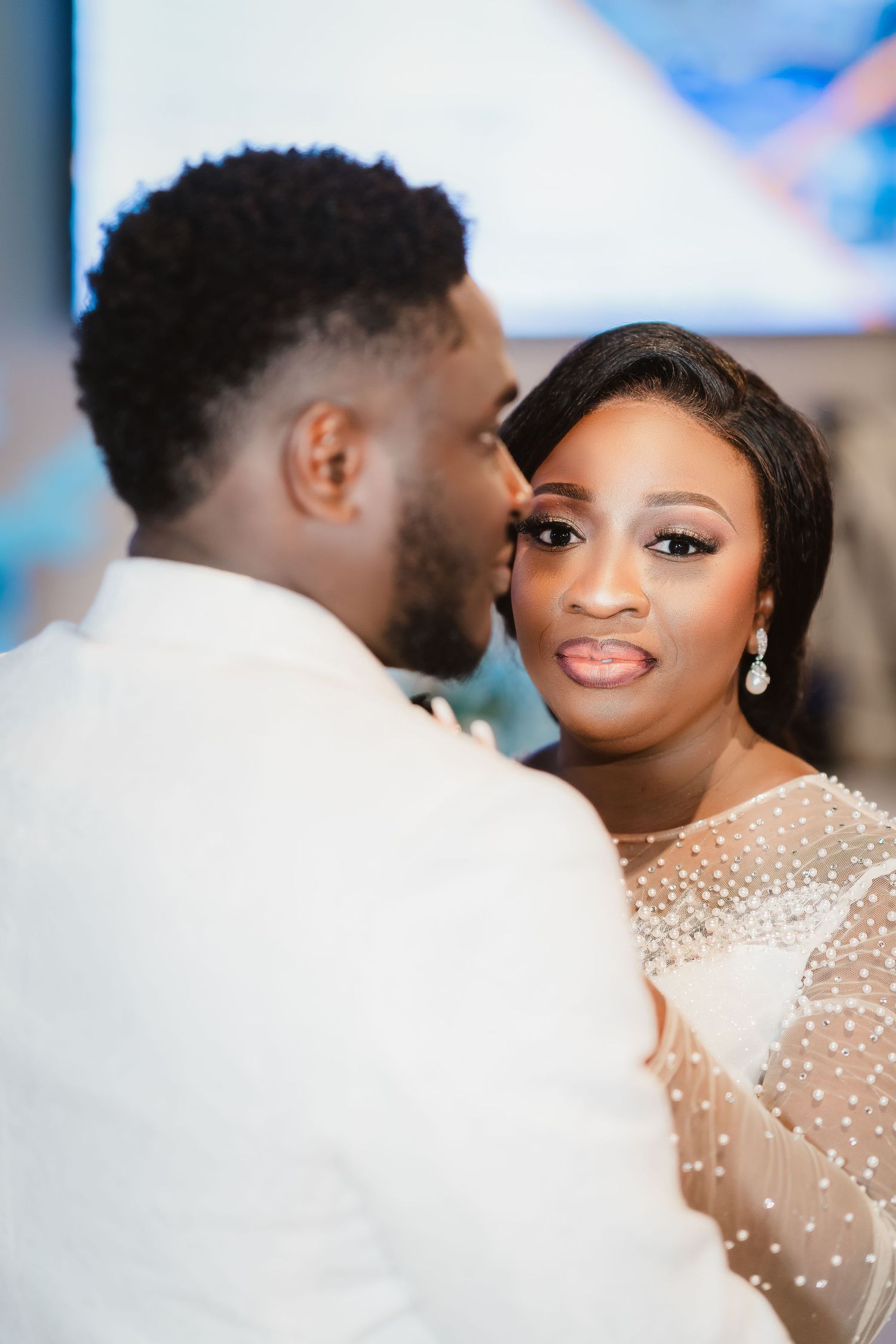 A couple shares an intimate moment during their first dance at a wedding reception.