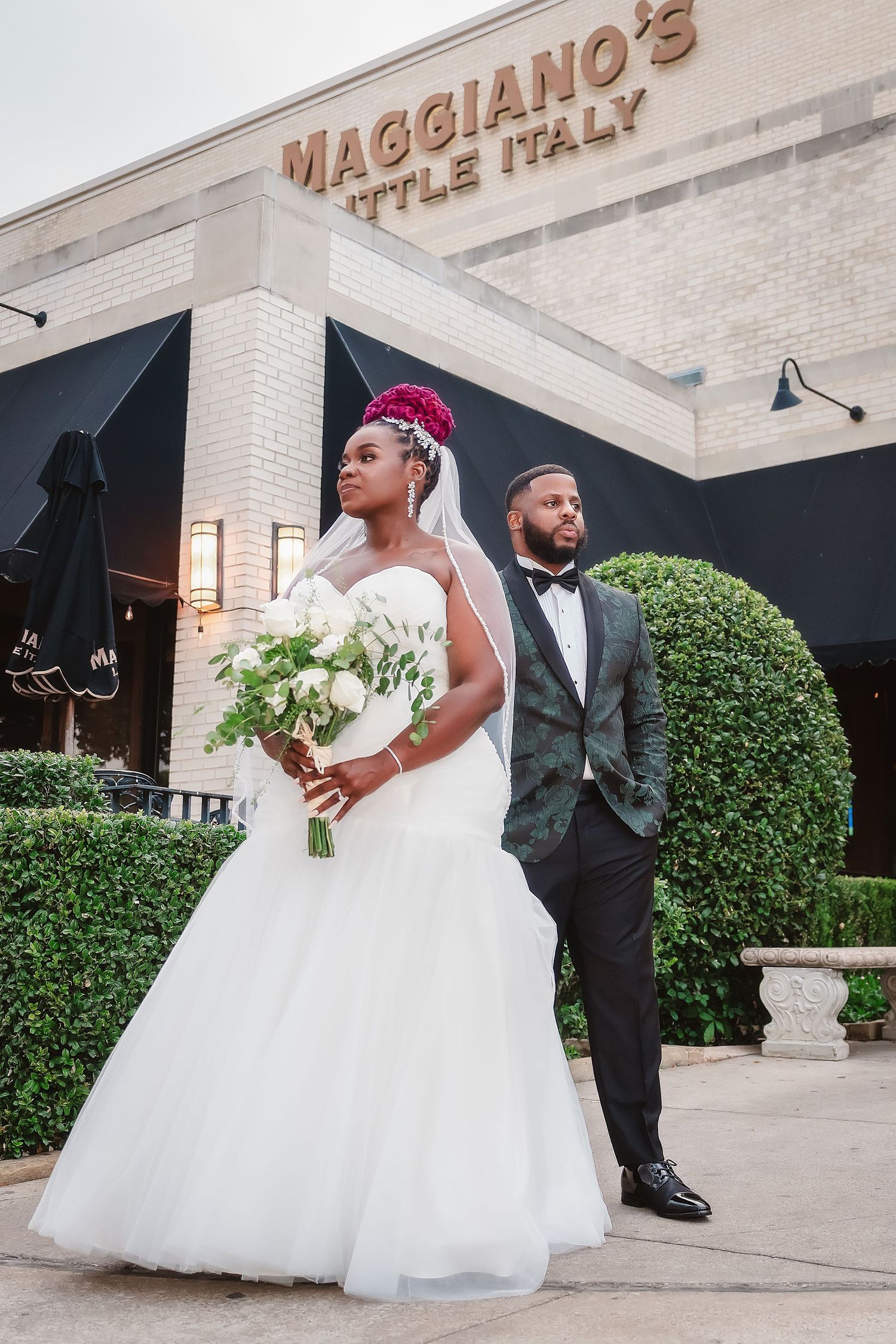 Elegant wedding photos outside Maggiano's restaurant showing bride in flowing white gown and groom in dark suit.