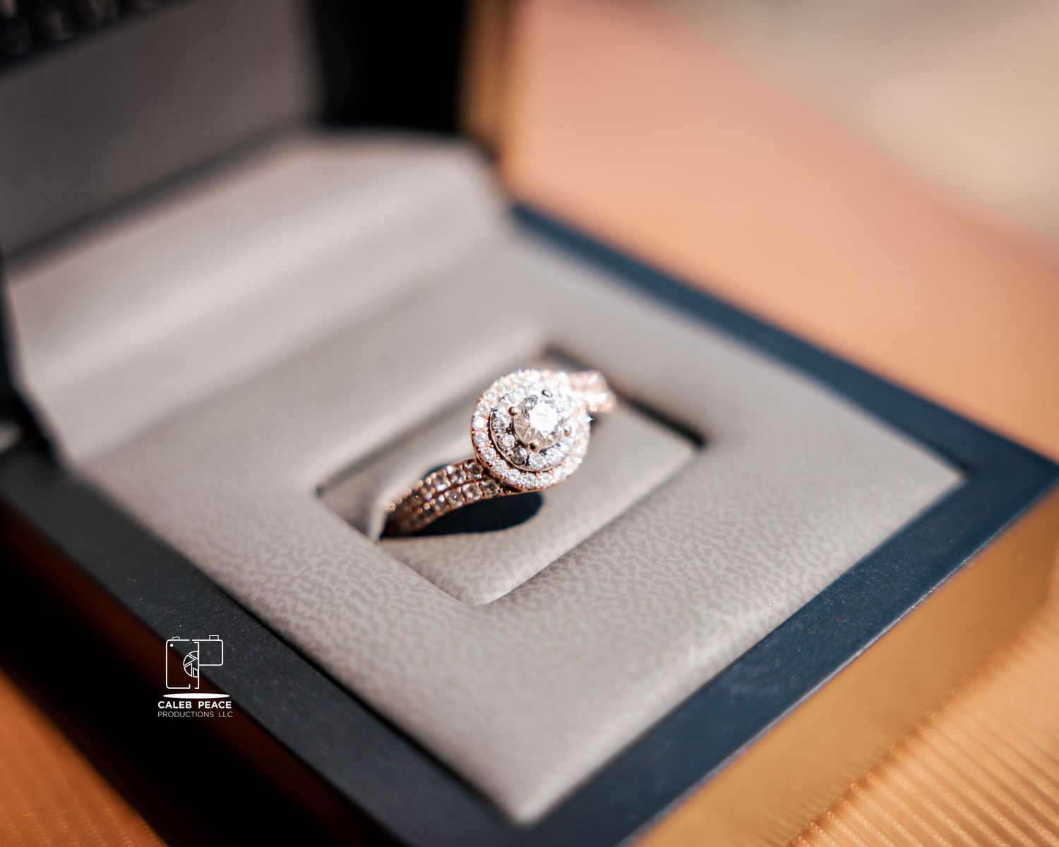 A stunning diamond engagement ring sits in a navy blue velvet box.