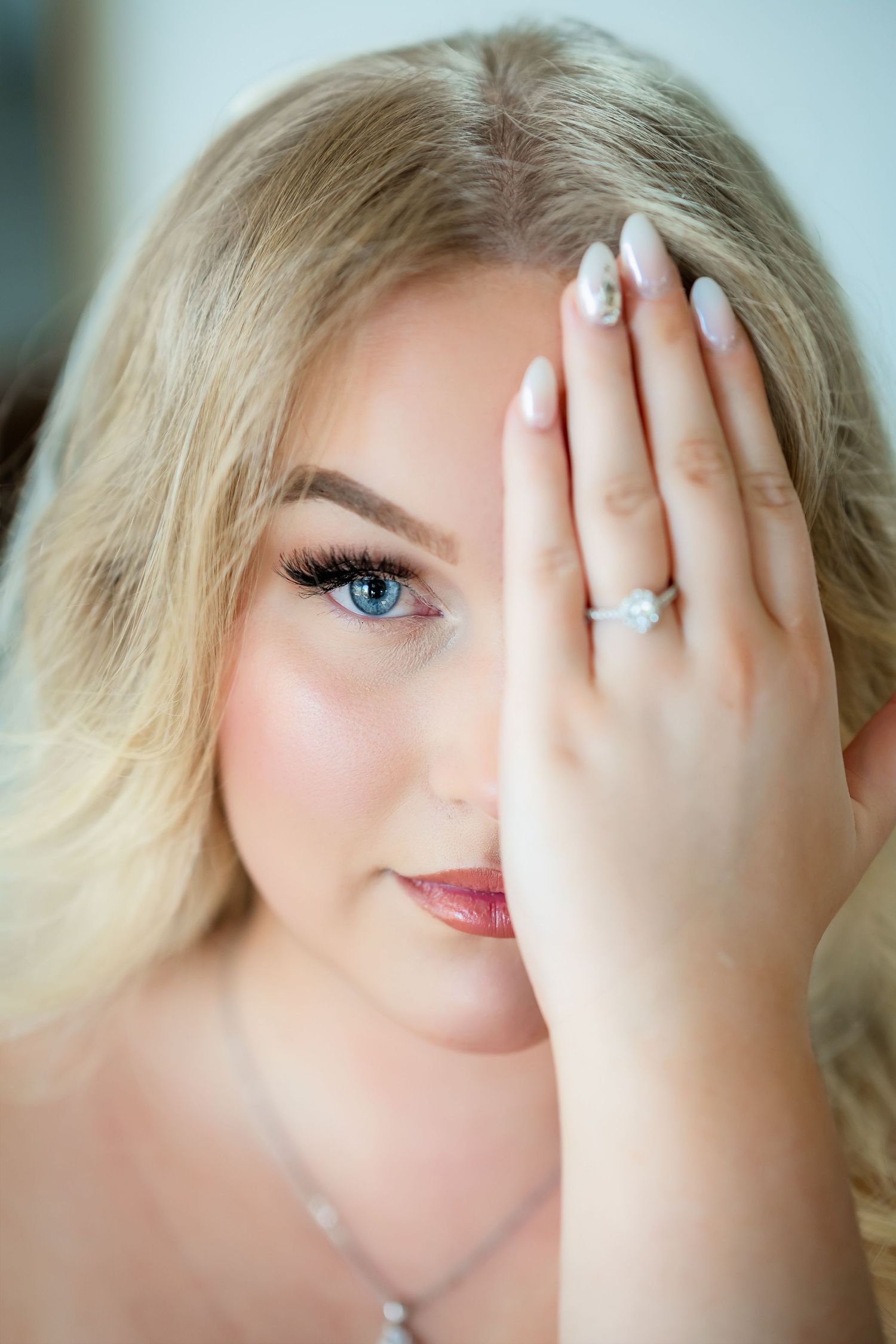 Artistic boudoir photography with soft lighting and natural makeup details.