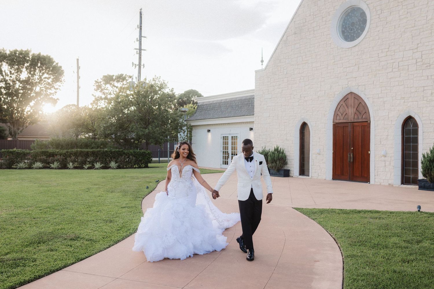 Wedding photos captured outside a white church building during golden hour.