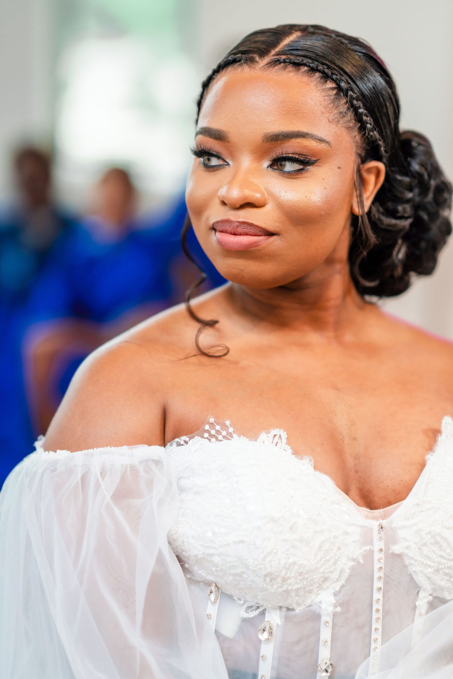Close-up portrait of a bride wearing an elegant white lace wedding dress.