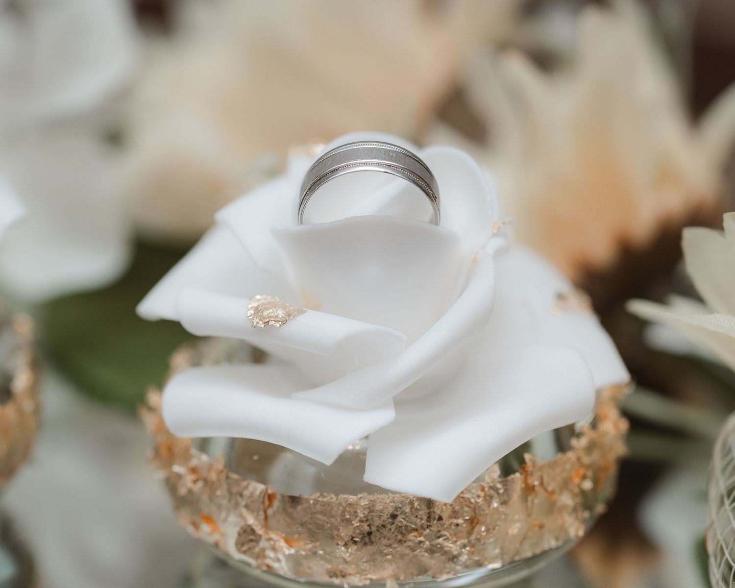 White rose petals and delicate floral arrangements create an elegant wedding setting.