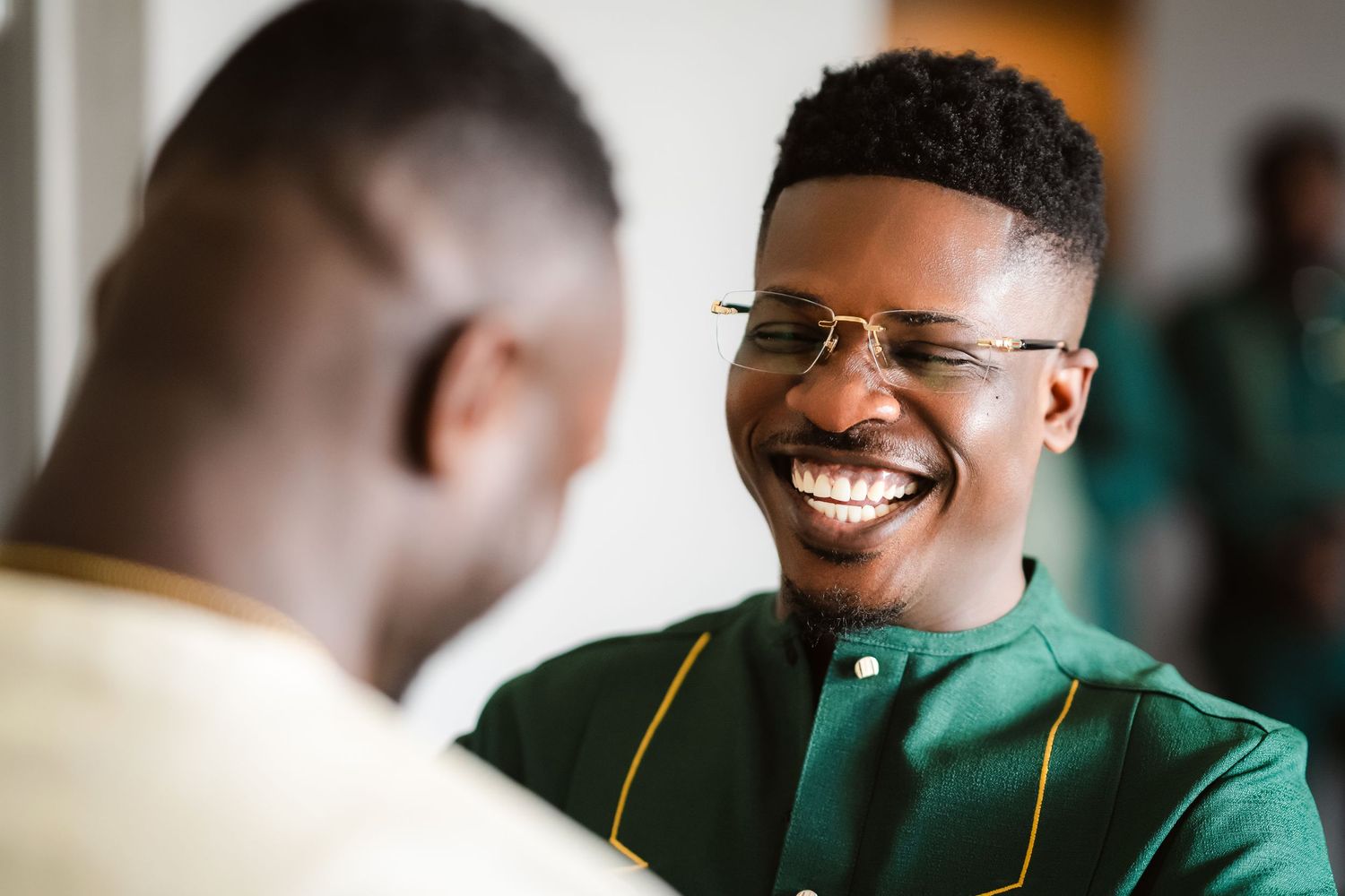 Two people sharing a joyful moment while wearing green formal attire.