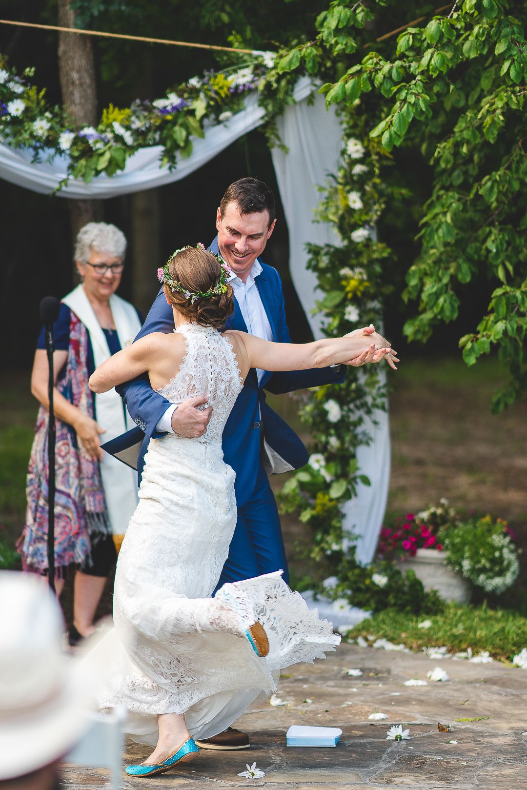 A celebratory moment during a garden wedding with guests looking on.