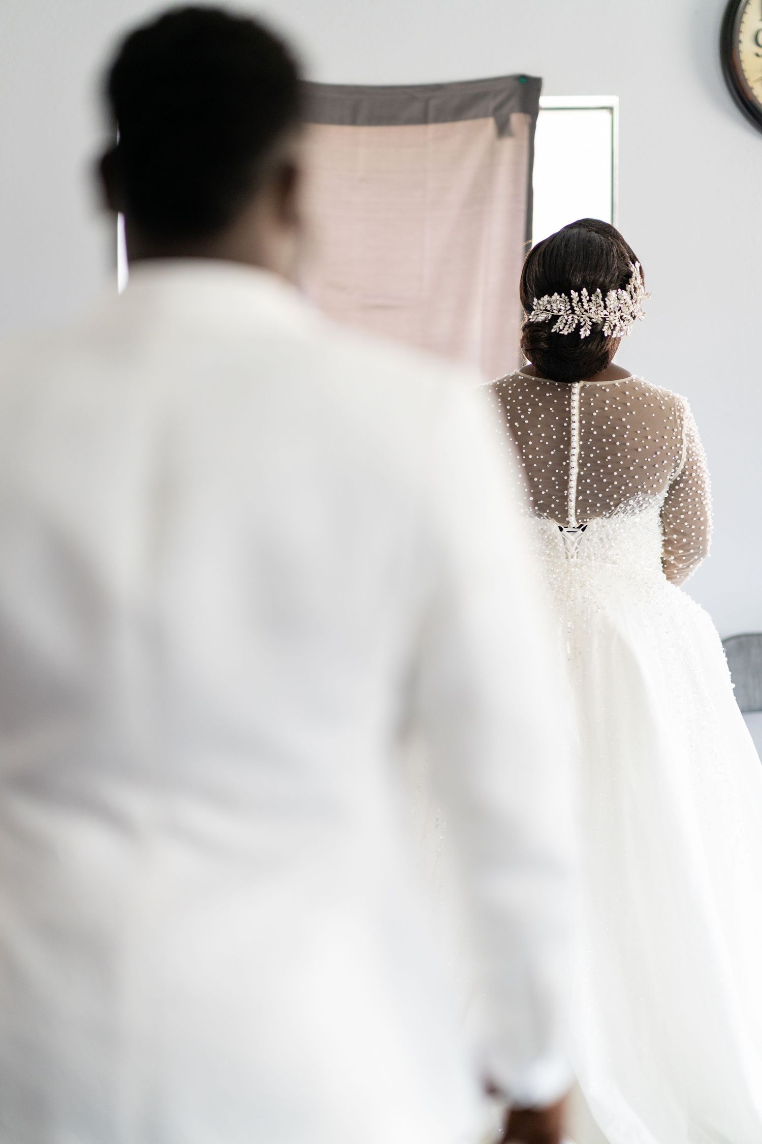 A soft focus shot of a bride in a delicate lace dress from behind.