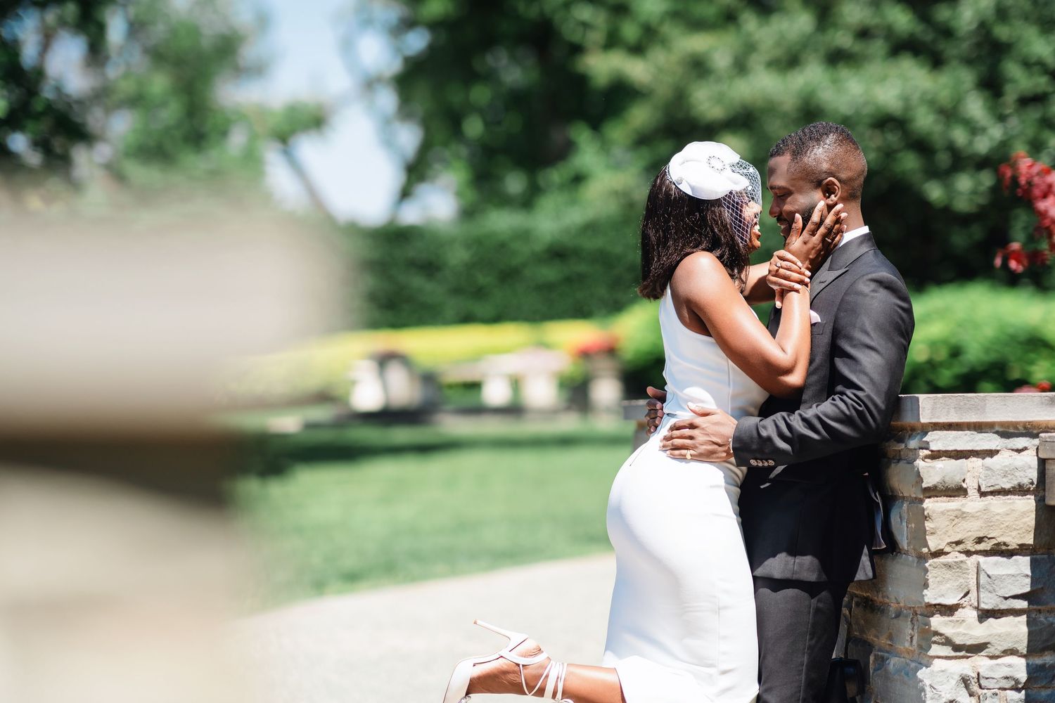 A wedding couple shares an intimate moment in a lush garden setting.