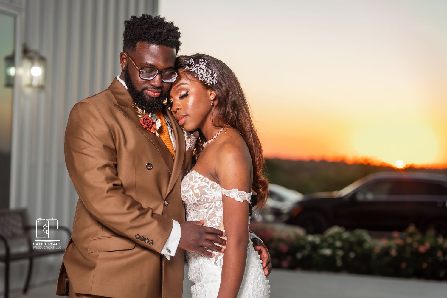 A romantic wedding couple embracing during golden hour sunset in formal attire.