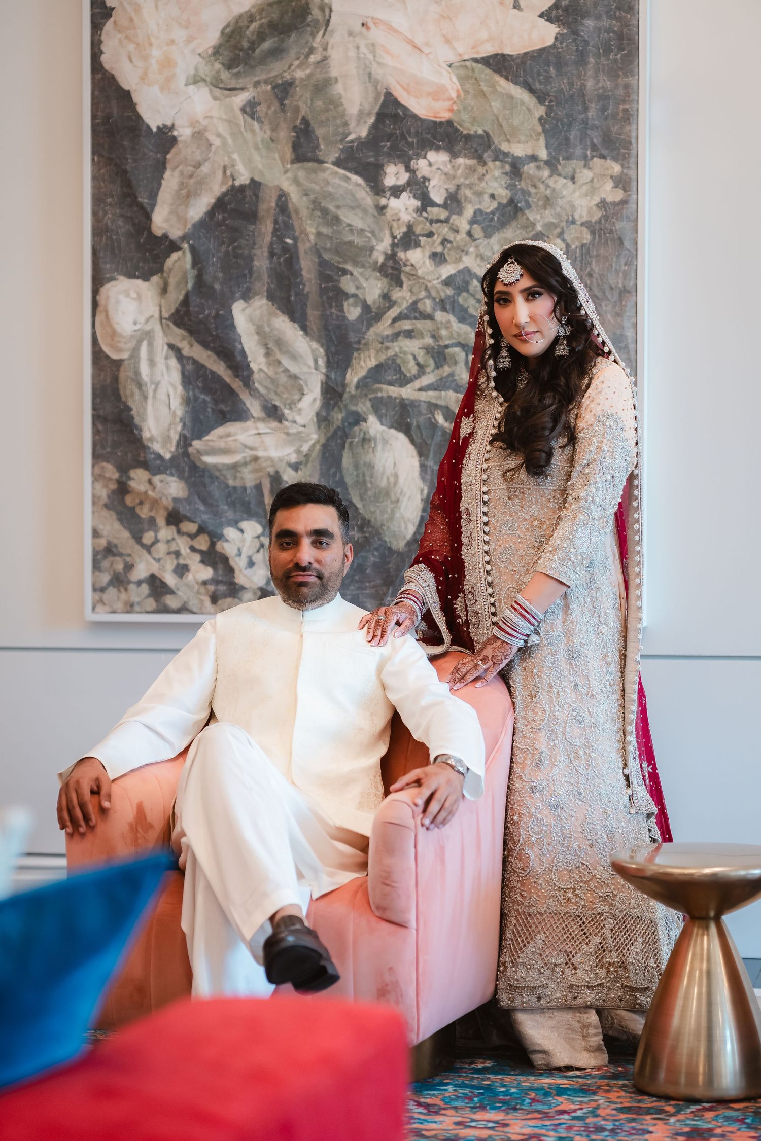 Intimate wedding photoshoot featuring traditional South Asian attire against an artistic wall backdrop.