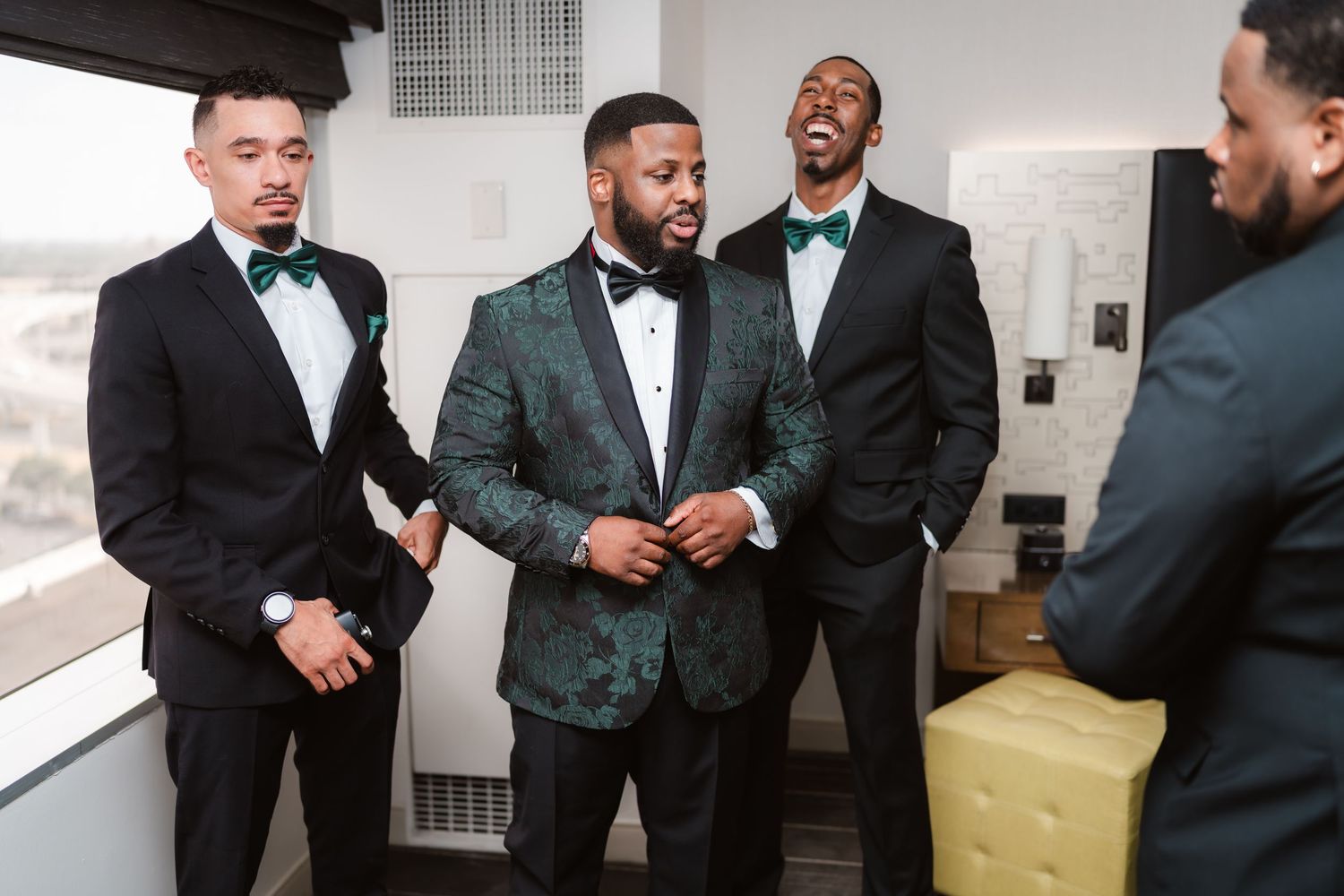 A group in formal black tuxedos and bow ties gather together in a celebratory setting.