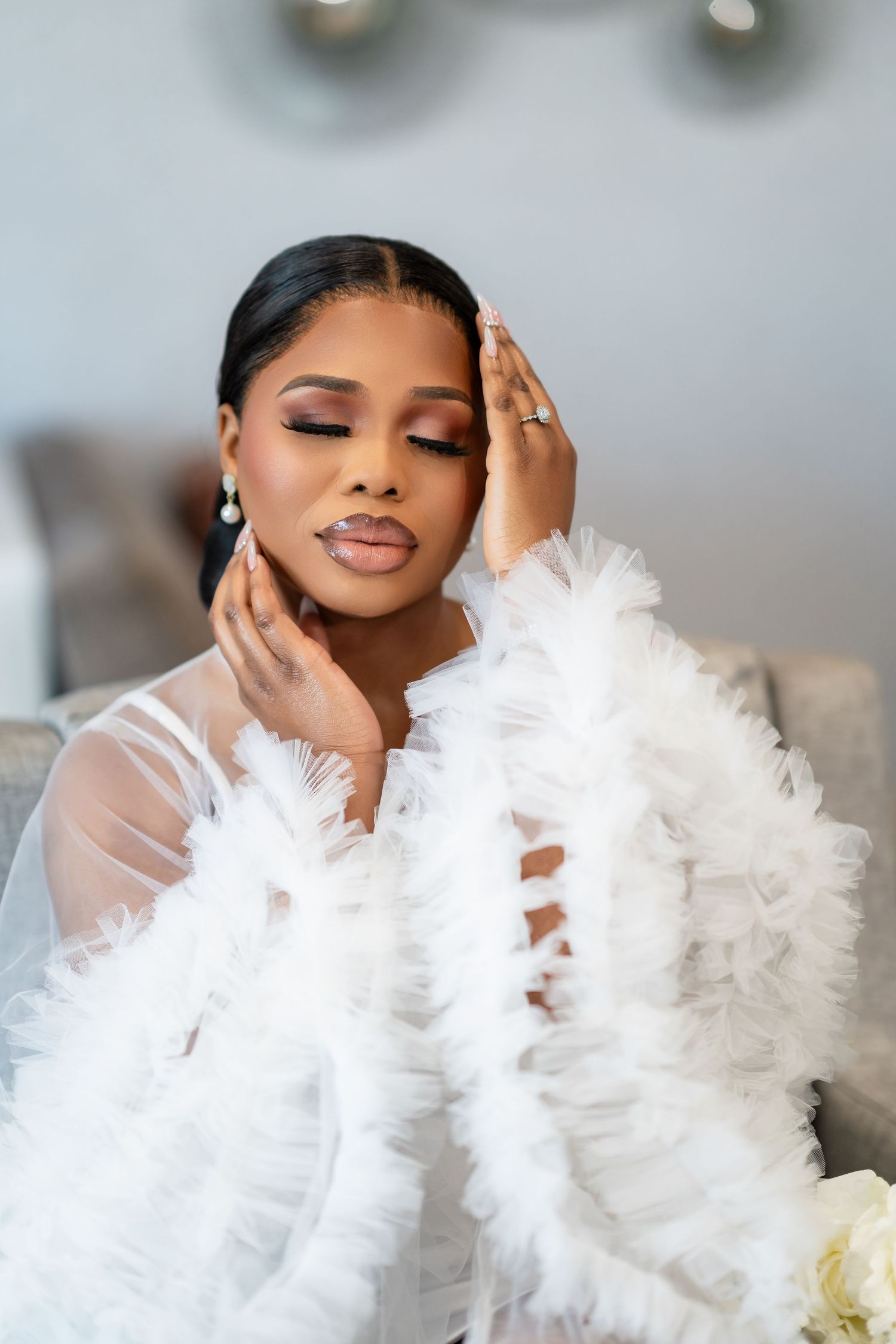 Glamorous white feathered robe with sheer details photographed in studio setting.