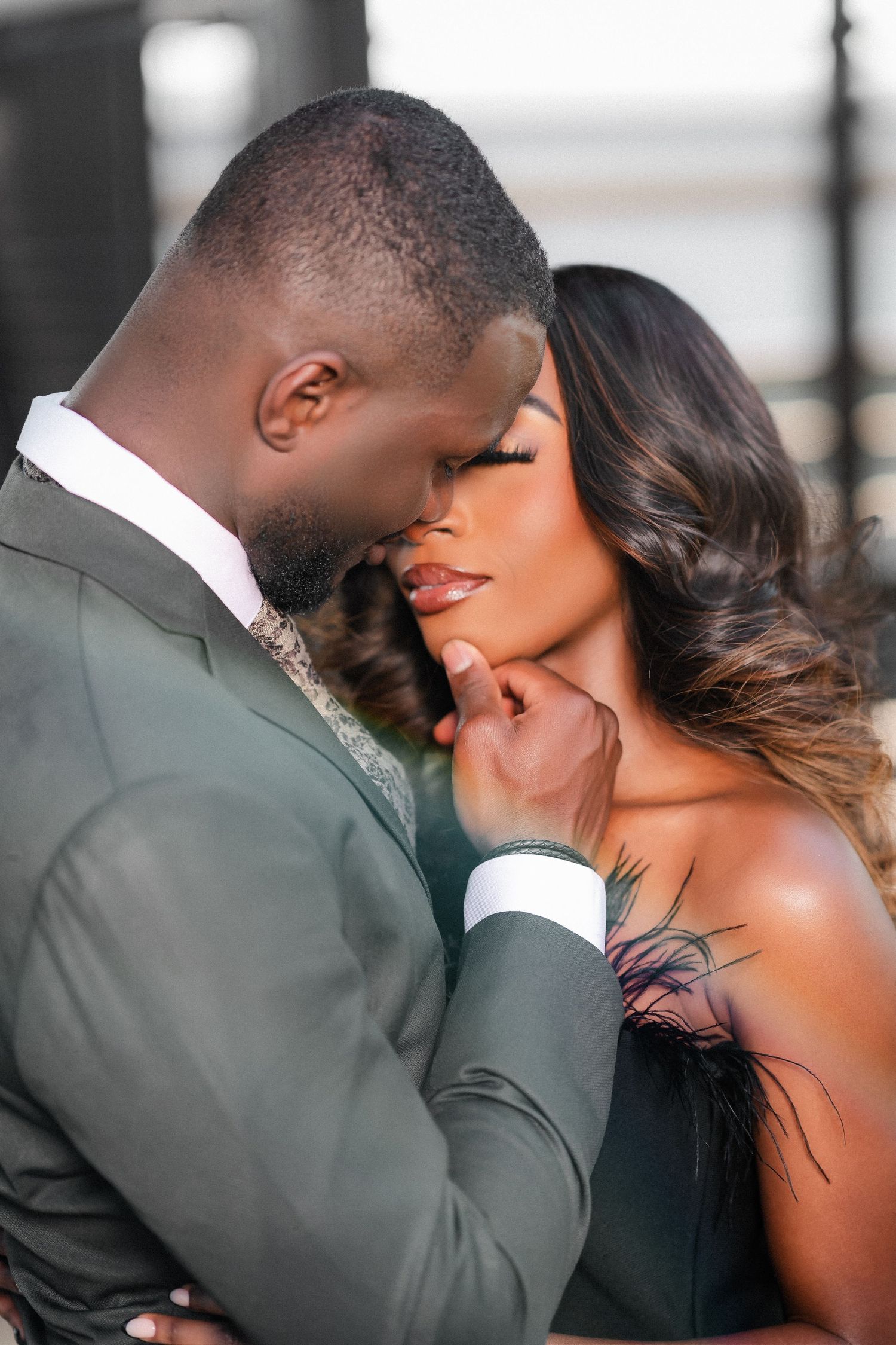 Intimate portrait of a couple in formal attire sharing a tender romantic moment.