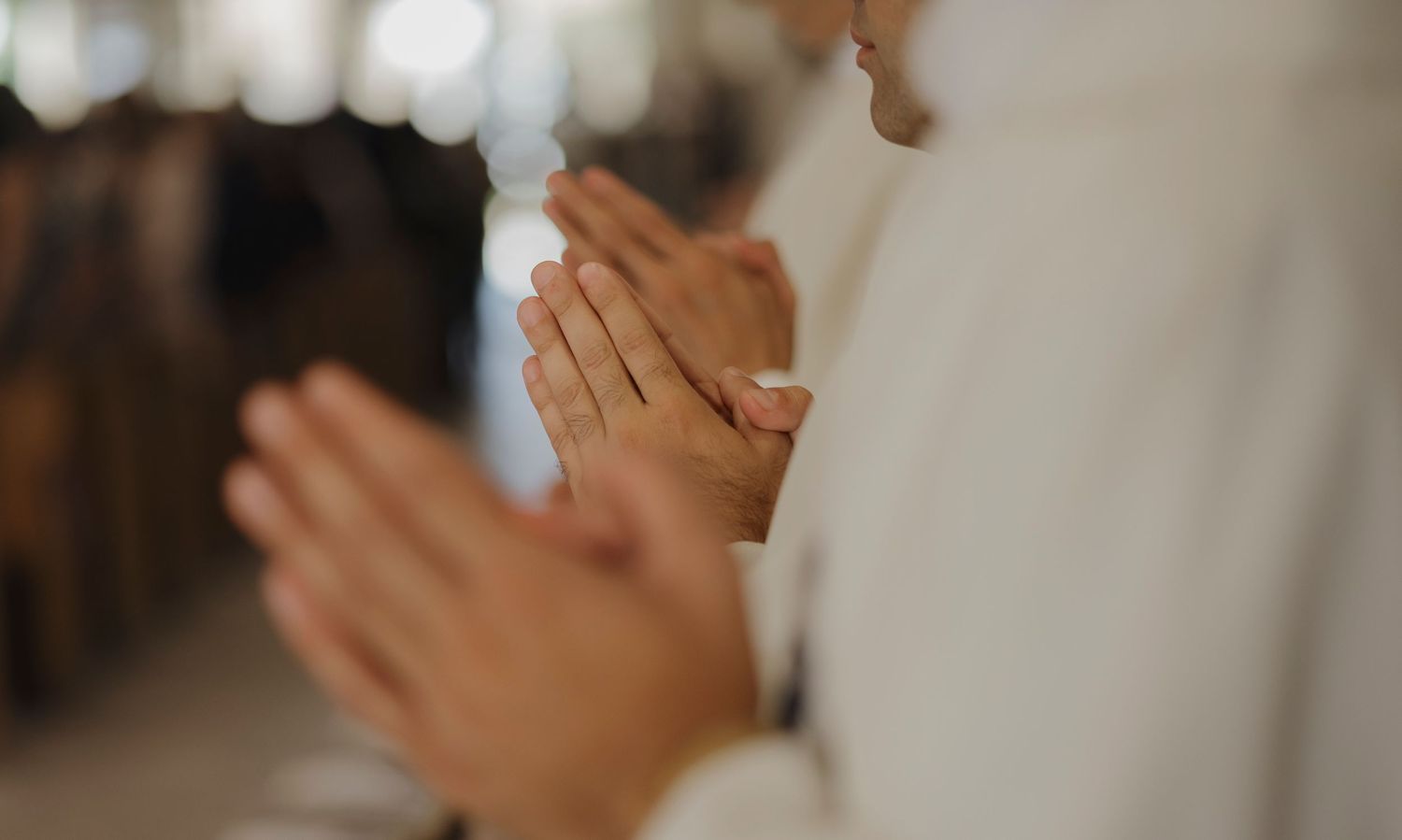 A group in white robes participates in a solemn religious ceremony.