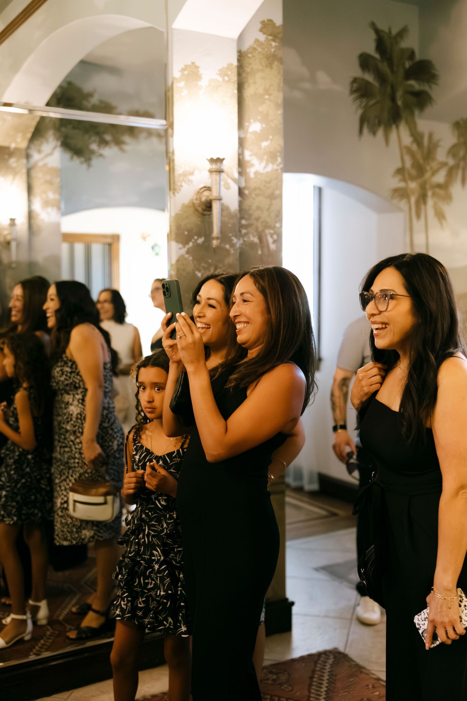 Group of women laughing and enjoying themselves at an elegant indoor event.