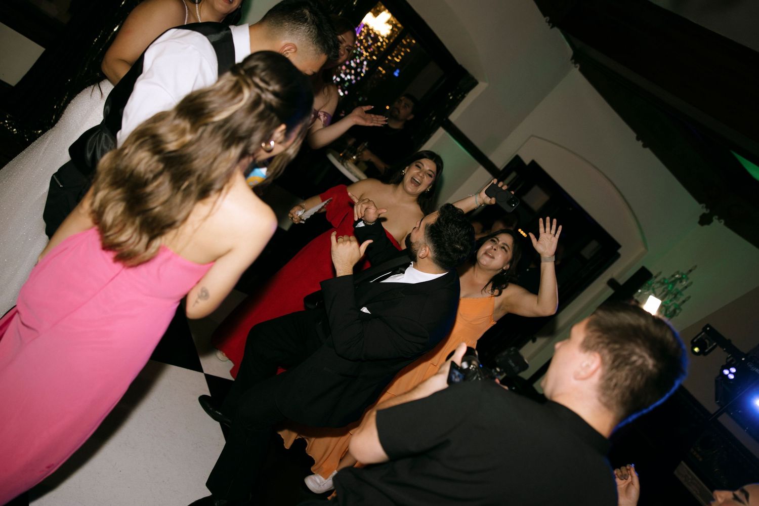 Energetic crowd dancing and celebrating at a nighttime party event.