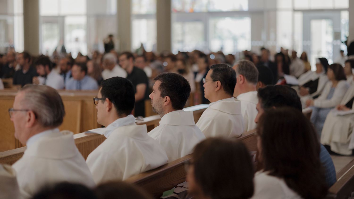A congregation gathers in a bright church sanctuary for worship.
