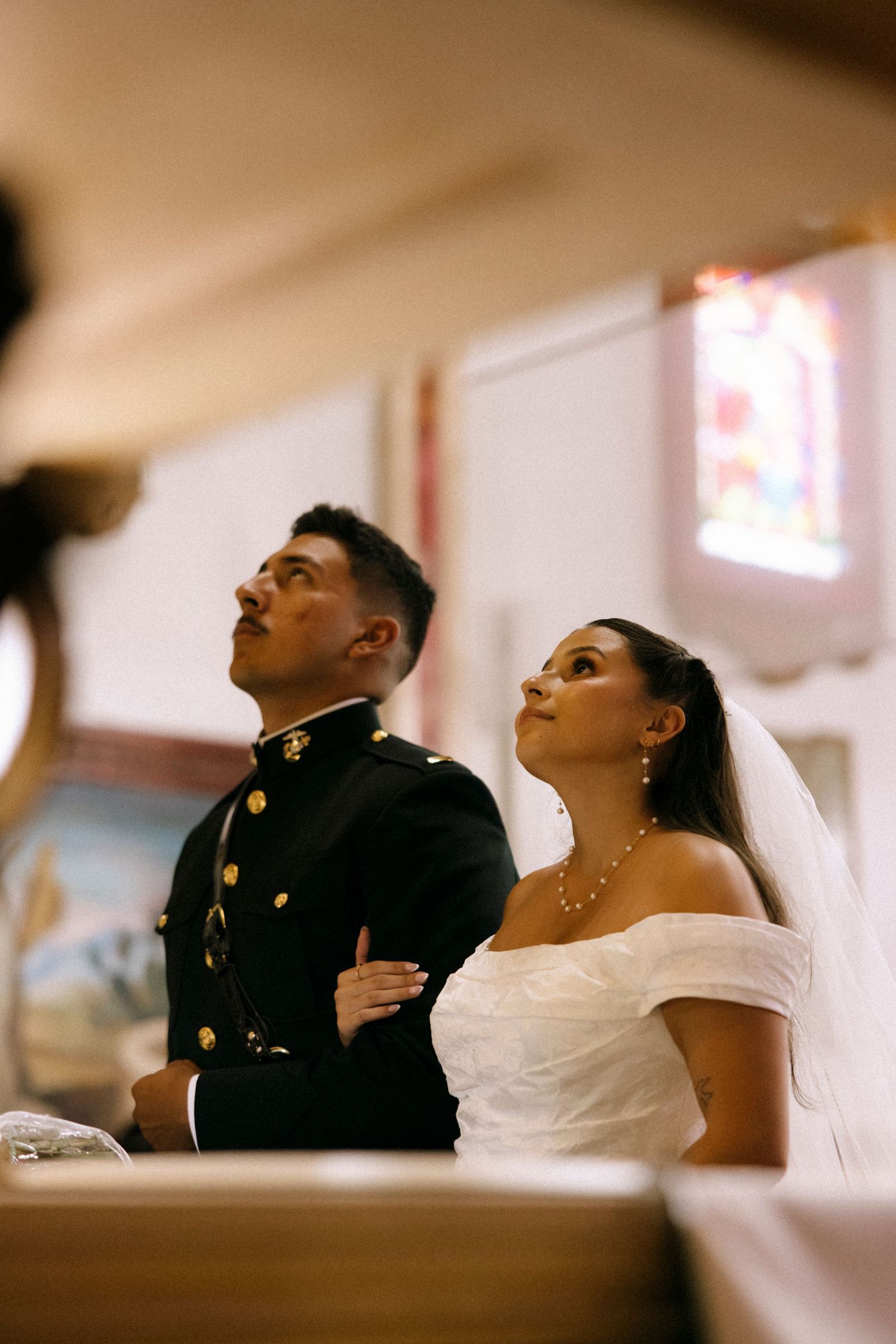 A joyful couple shares an intimate moment during their wedding ceremony in a church.