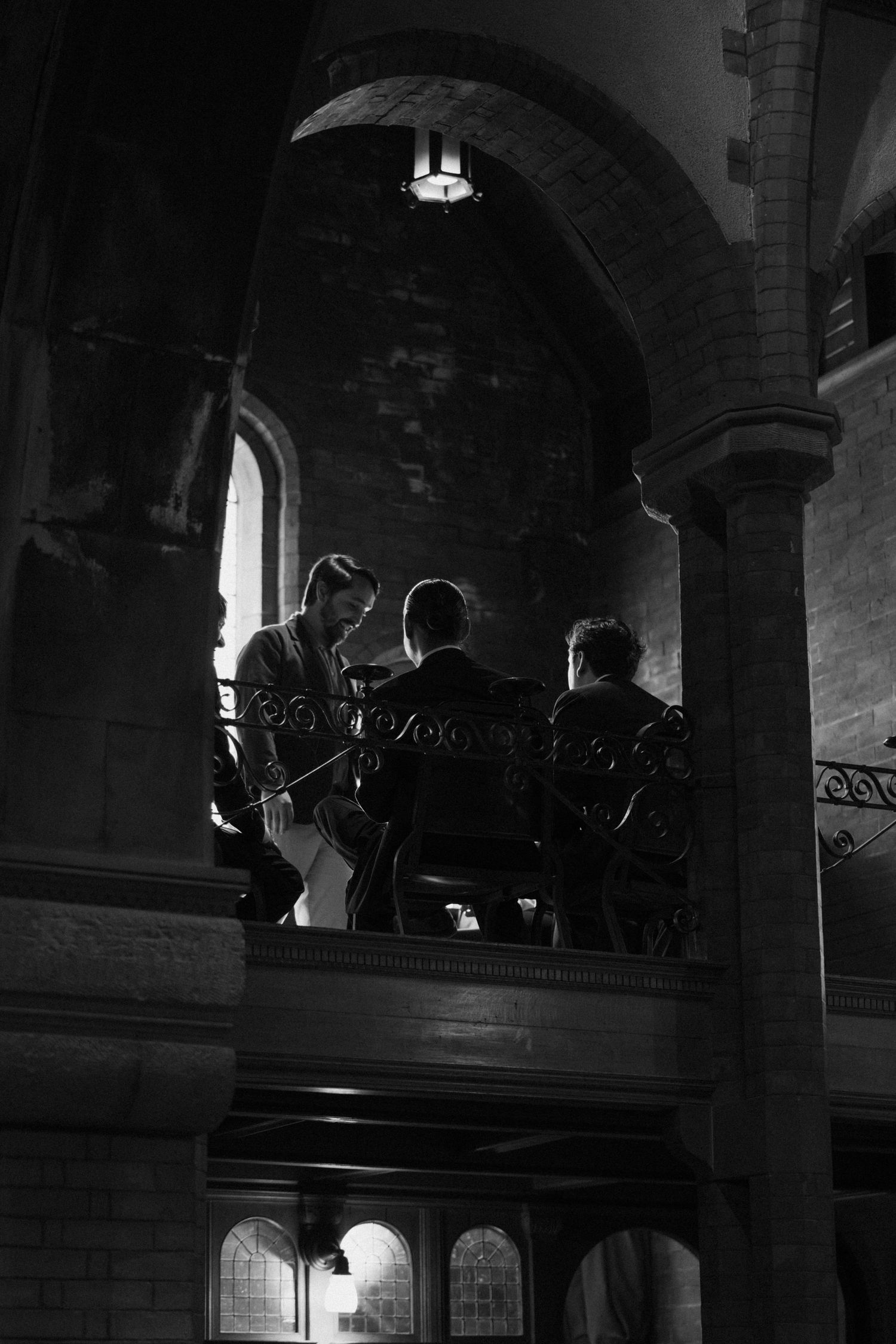 Silhouettes of musicians performing in church balcony with ornate architectural details.