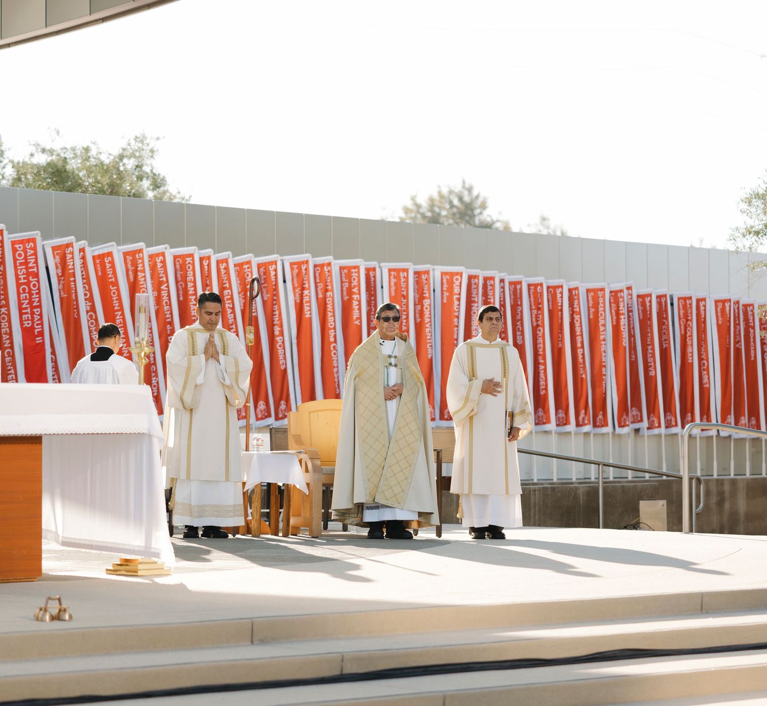 Red and white decorative banners line an outdoor ceremonial space with modern architecture.