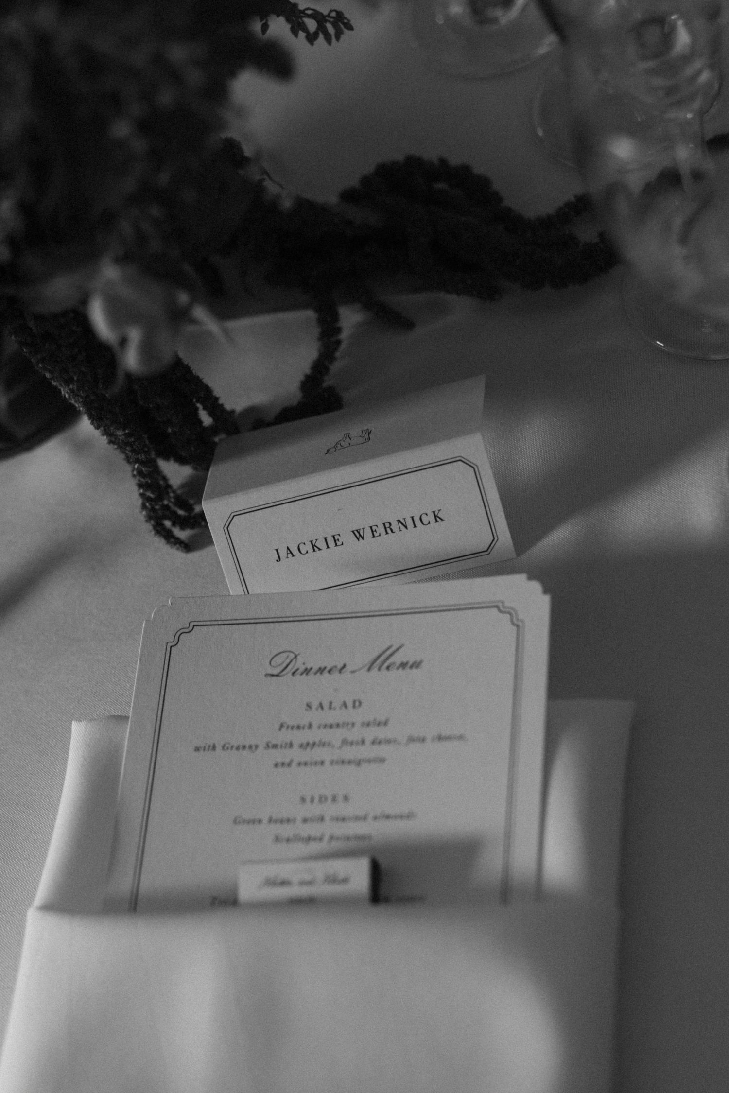 Black and white detail shot of wedding menu cards and place settings.