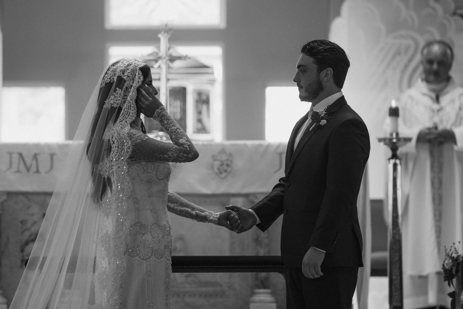 Wedding ceremony exchange at church altar with soft lighting.