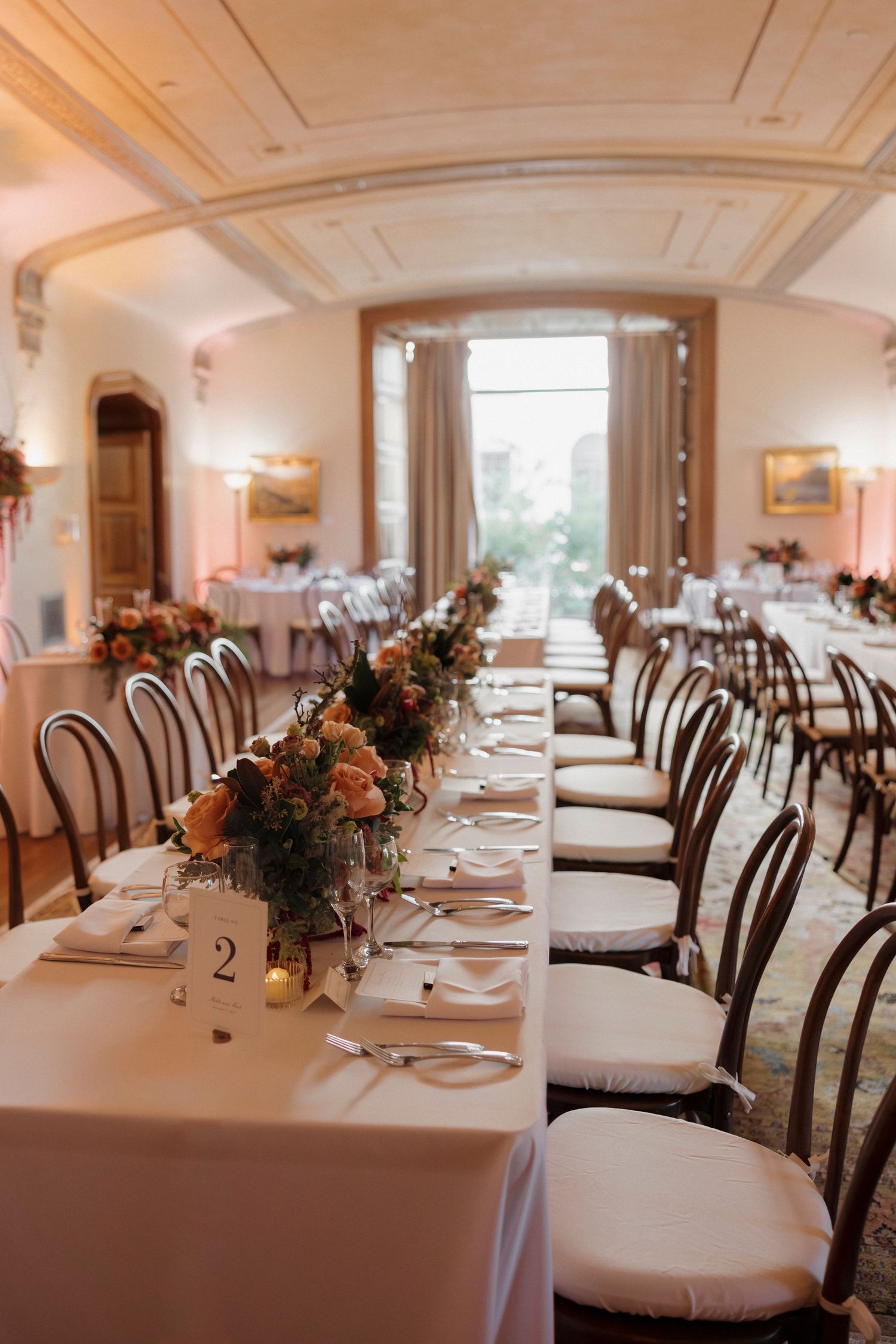 Wedding reception tables set with elegant place settings and floral centerpieces.