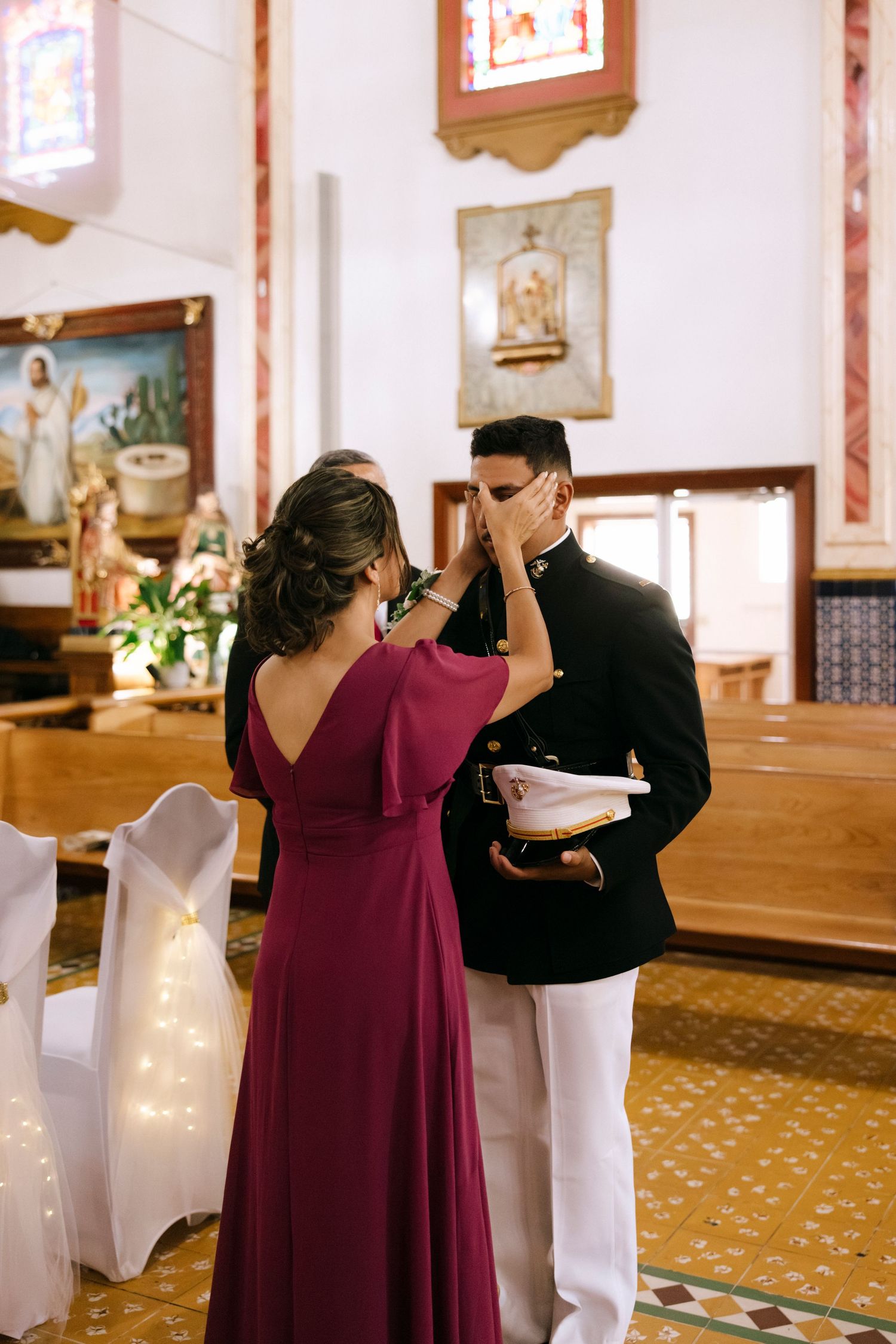 A wedding ceremony moment in a church with decorative stained glass windows and ornate details.