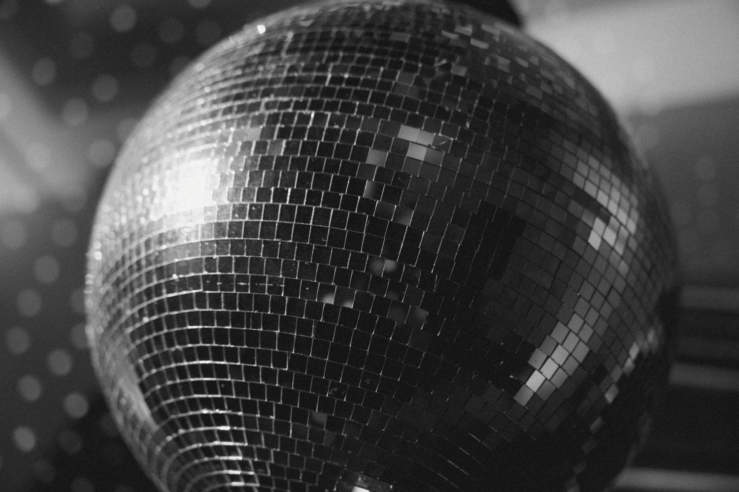 A disco ball reflects light and sparkles against a dark background at a party venue.