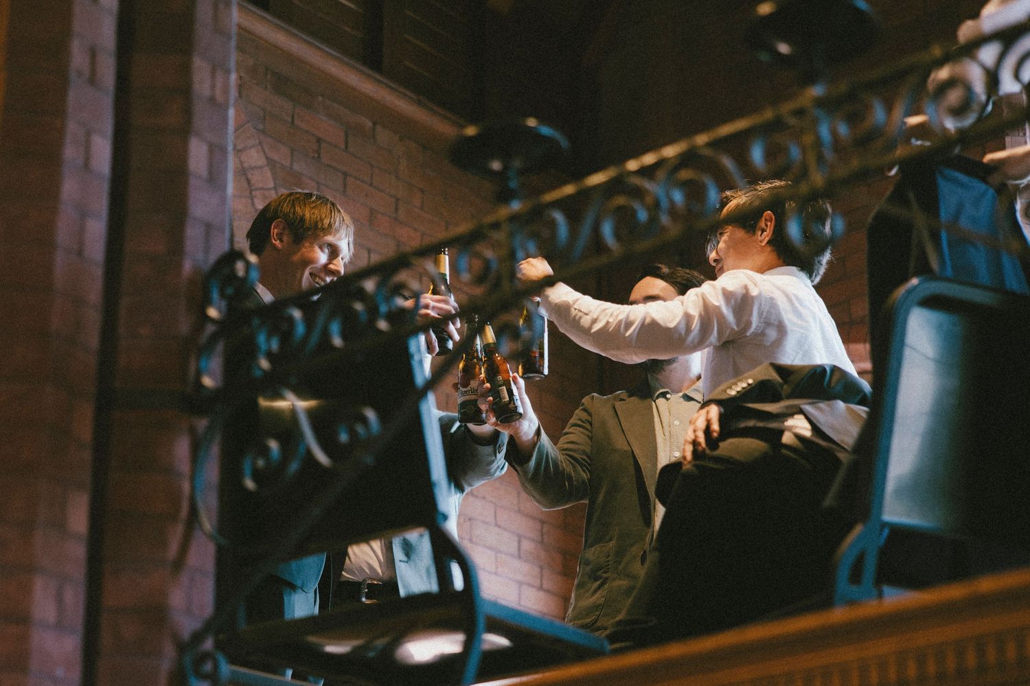 Behind-the-scenes view of audio technicians working at a sound booth during event.