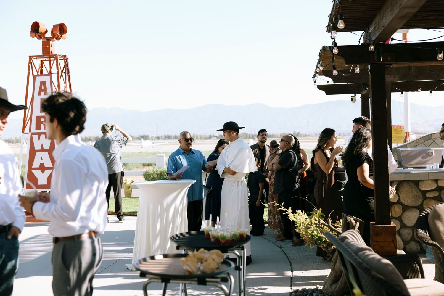Wedding guests mingling outdoors at a venue with scenic mountain views.