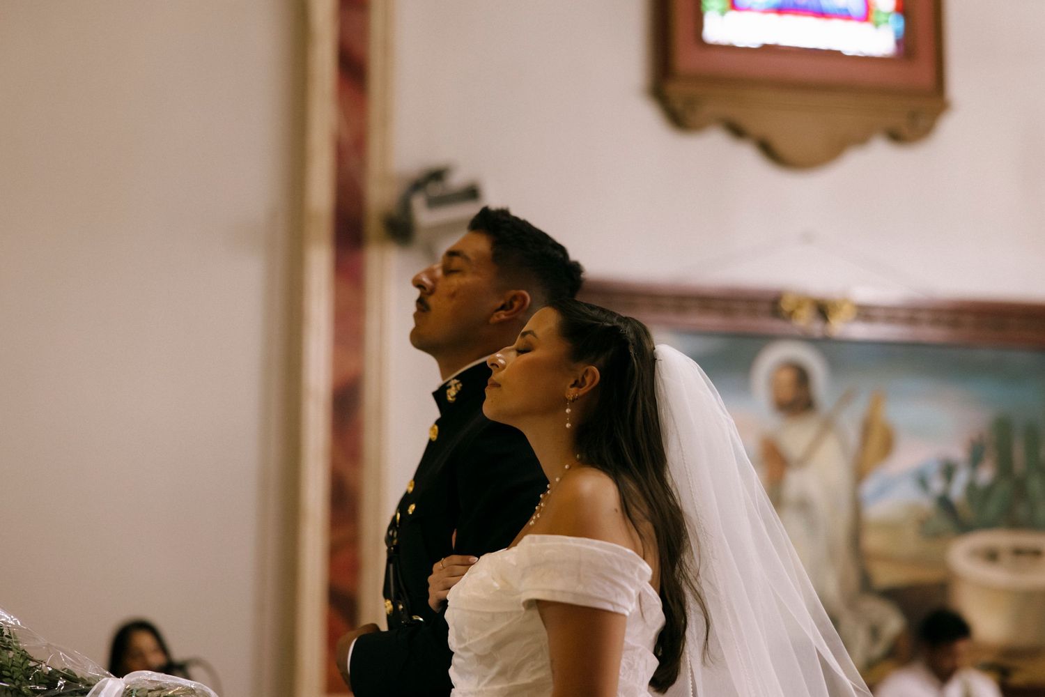 A couple shares an emotional moment during their wedding ceremony in an ornate church.
