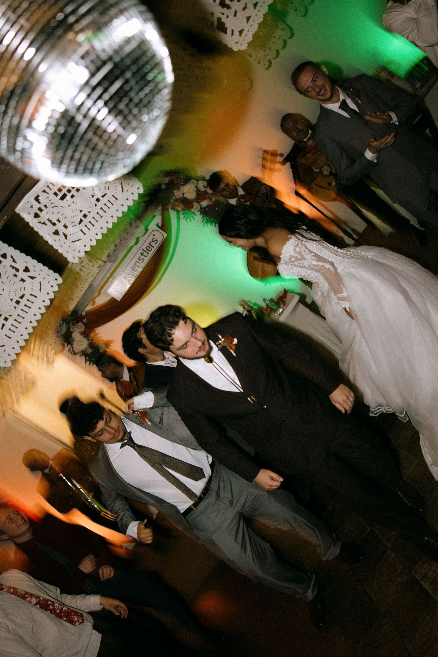 Dance floor scene with disco ball and green lighting creating a festive atmosphere.