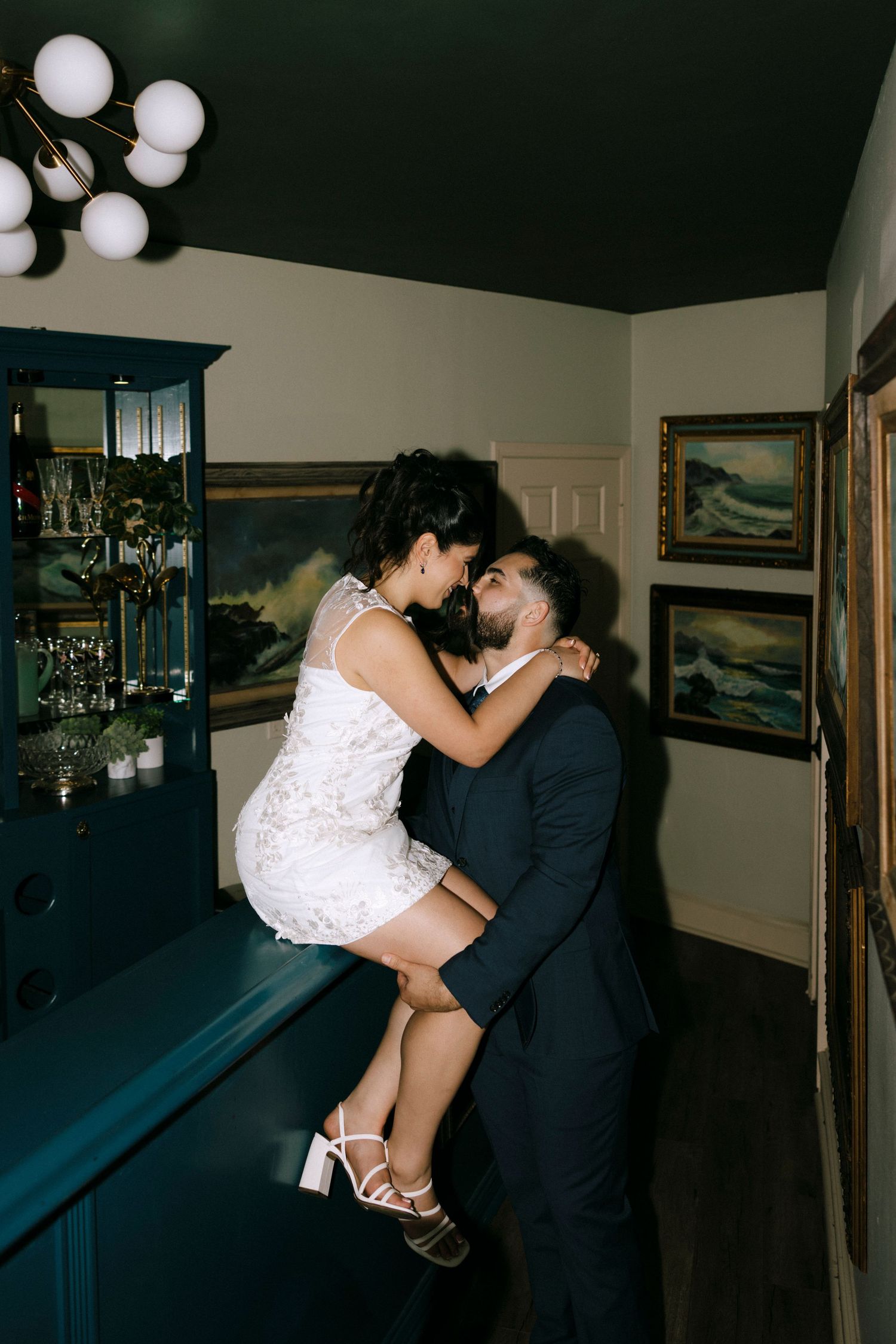 Romantic dance sequence in formal attire captured in low light with white balloons.