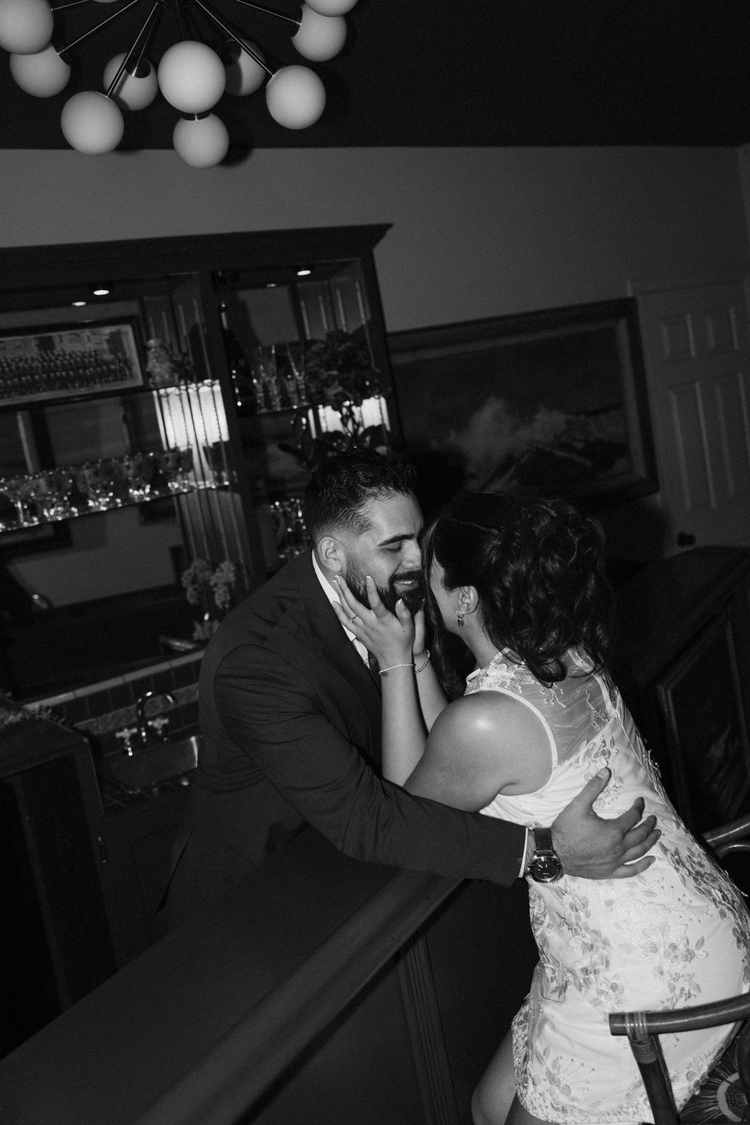 Black and white wedding reception scene with dance floor lighting and decorative balloons.