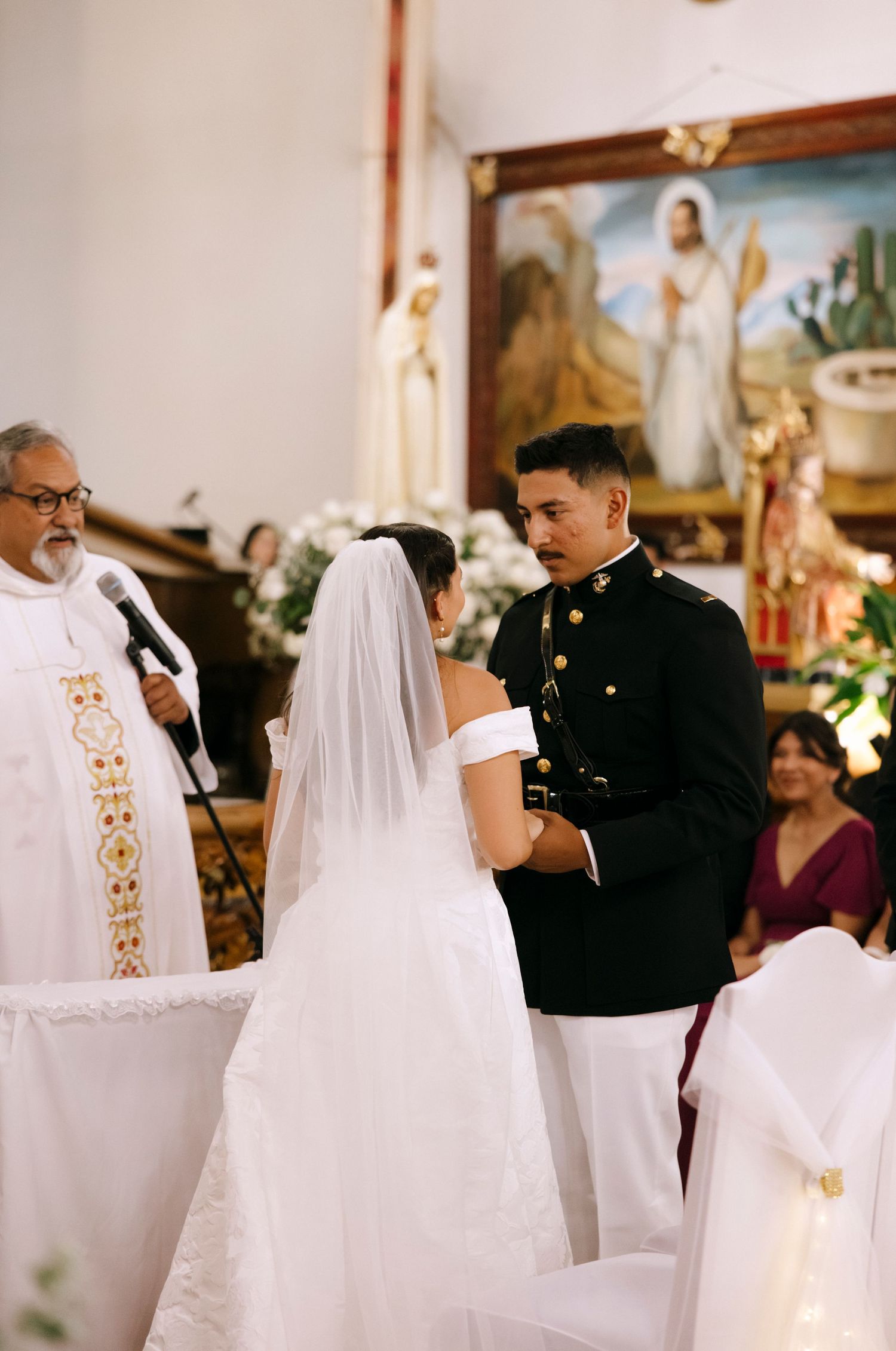 A priest presides over a military wedding ceremony at the church altar.