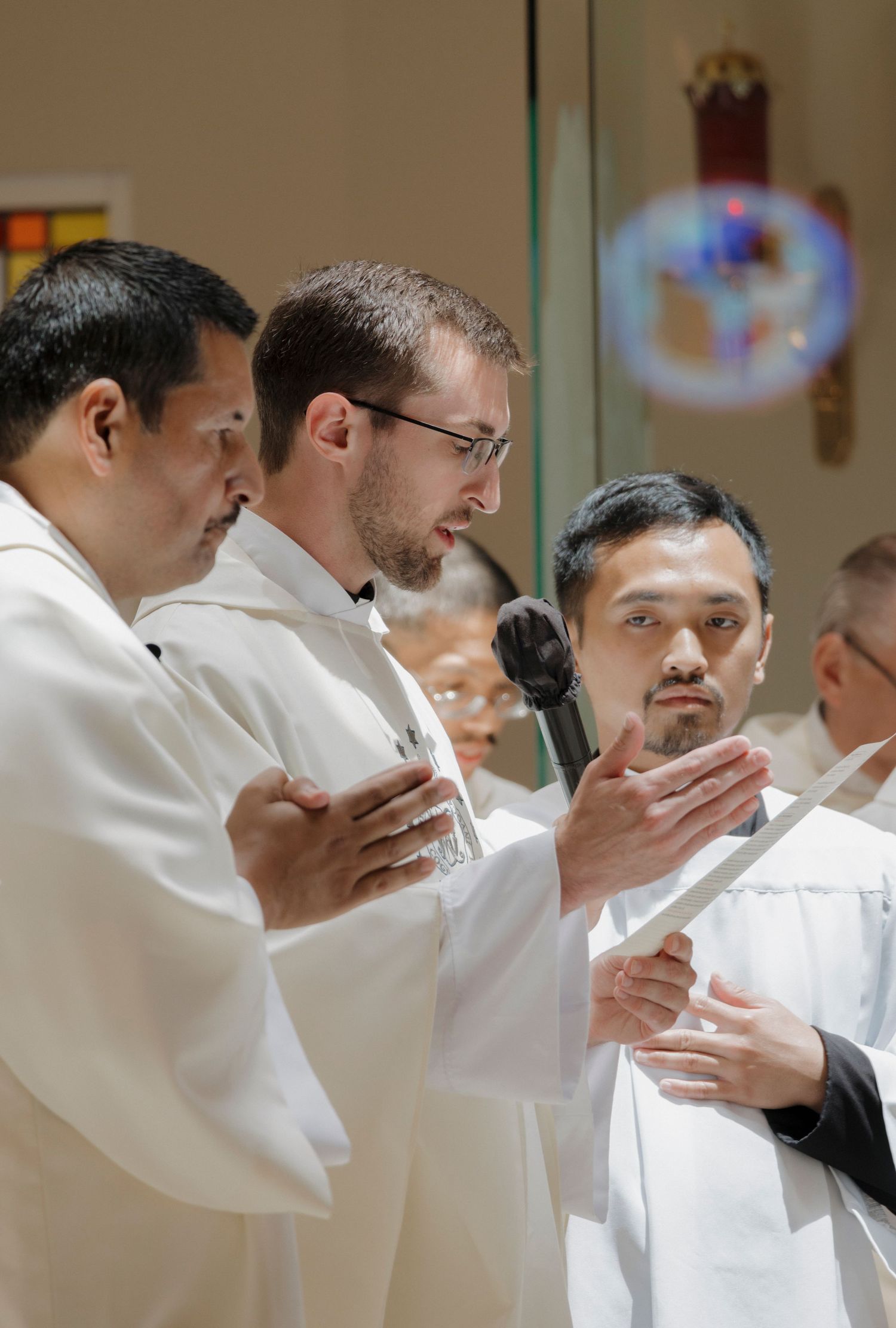 Group prayer during a religious ceremony with participants in white robes.