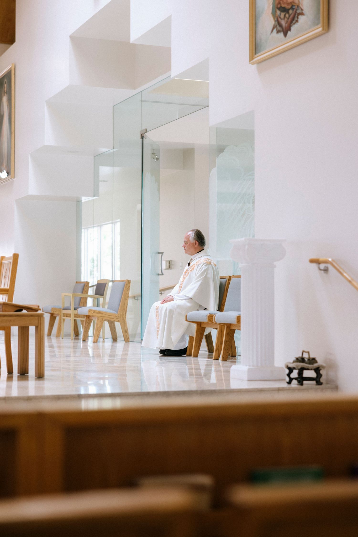 Side view of church altar and sanctuary during wedding ceremony with glass partitions.