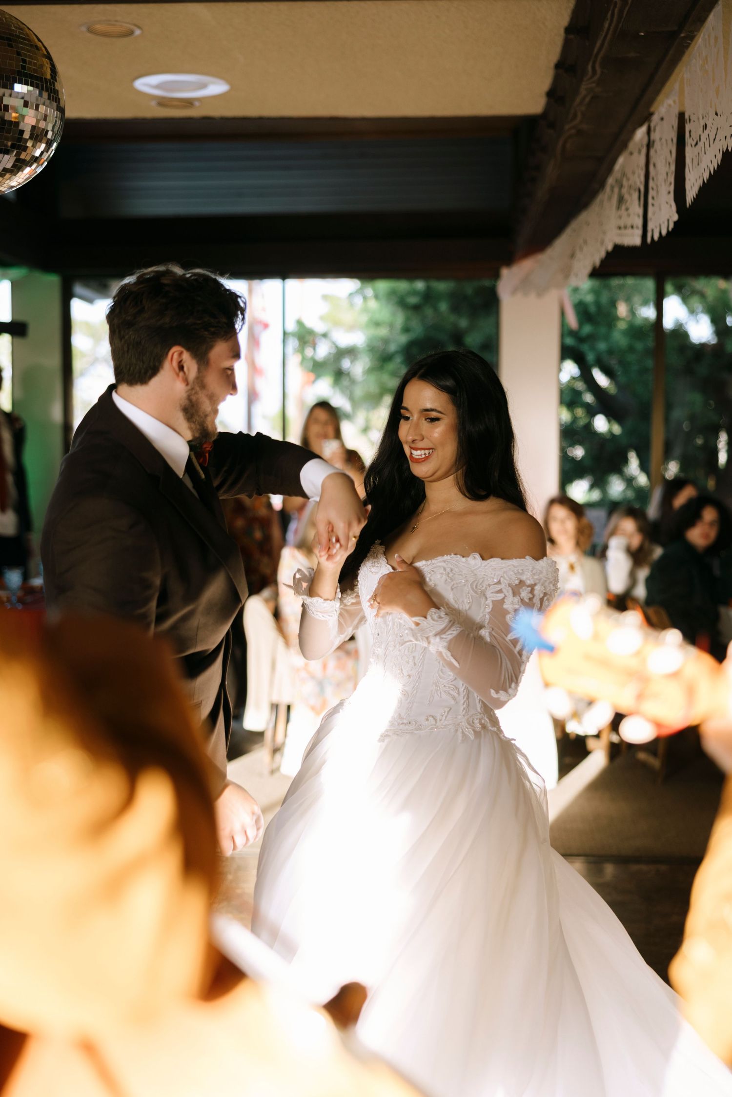 Wedding celebration with dancing couples in an elegantly decorated reception venue.