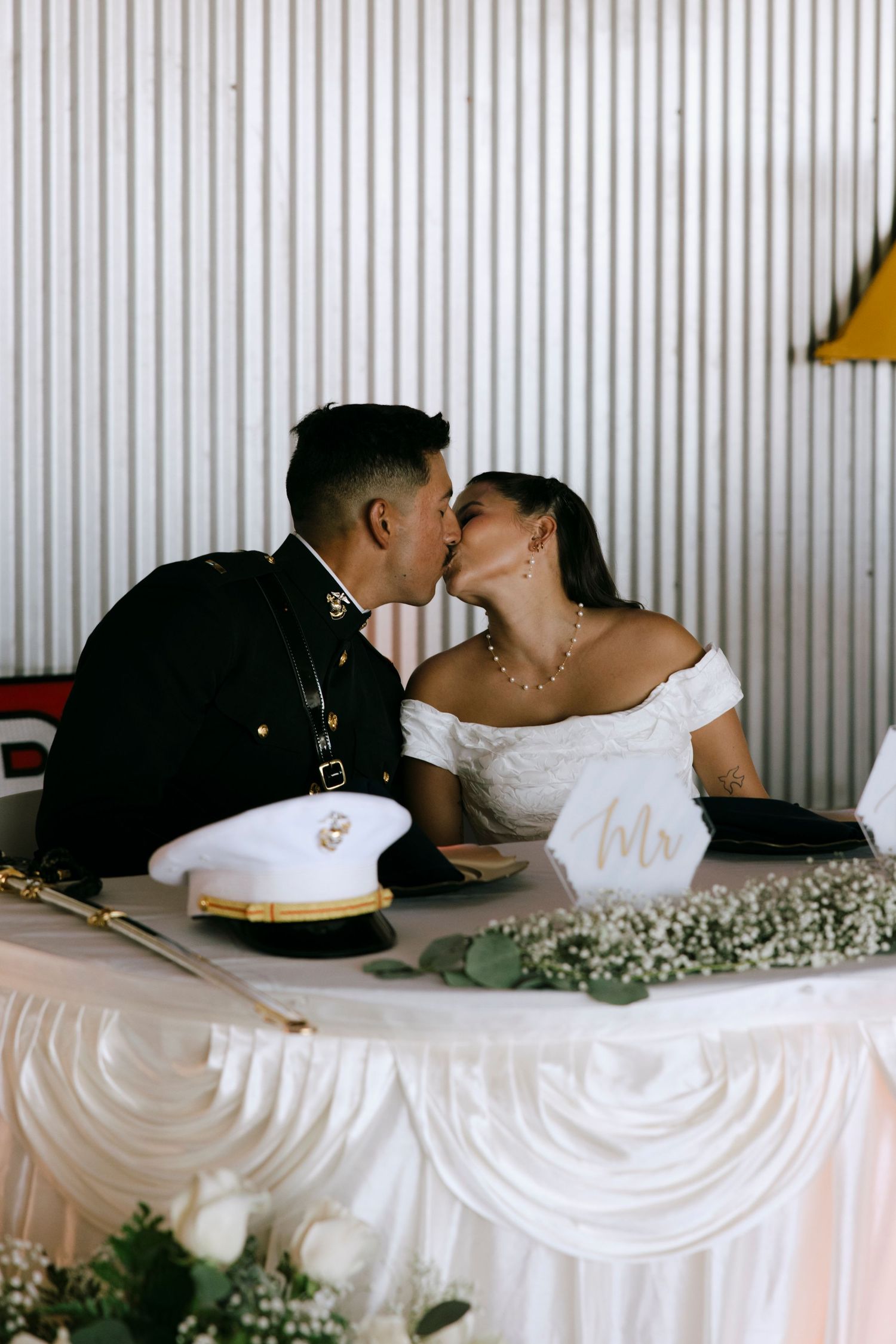 Newlyweds share intimate moment at decorated head table.