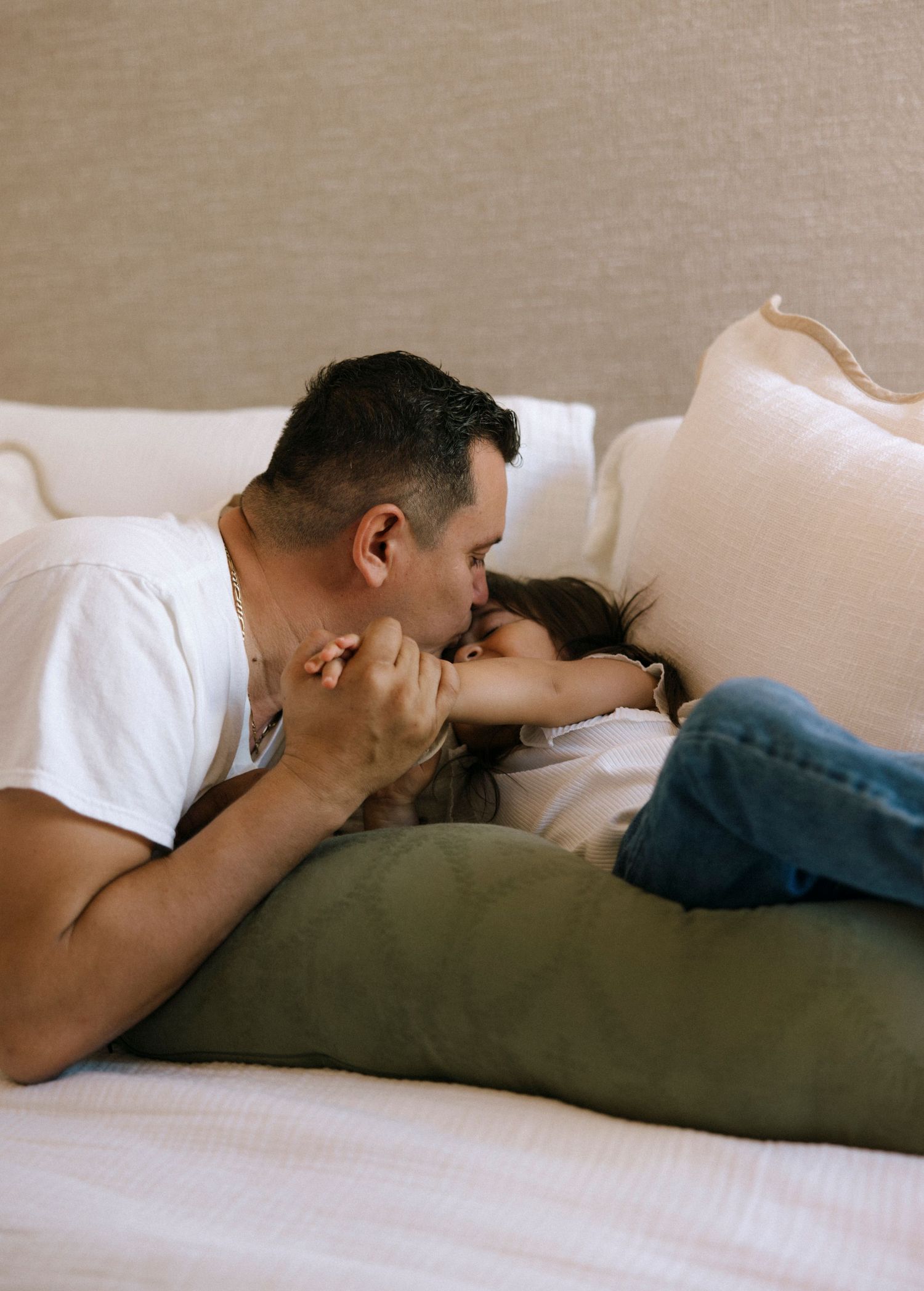 Intimate family moment captured in sequence on white couch.