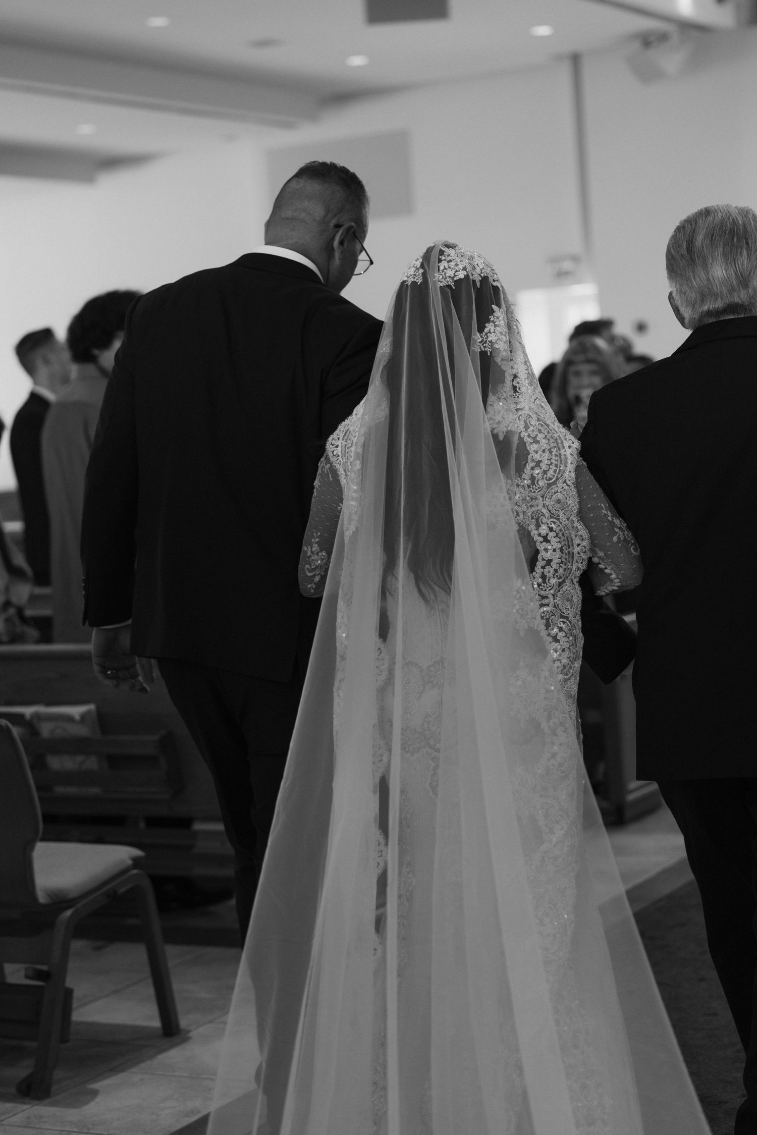 Wedding ceremony in progress with guests seated in church pews.