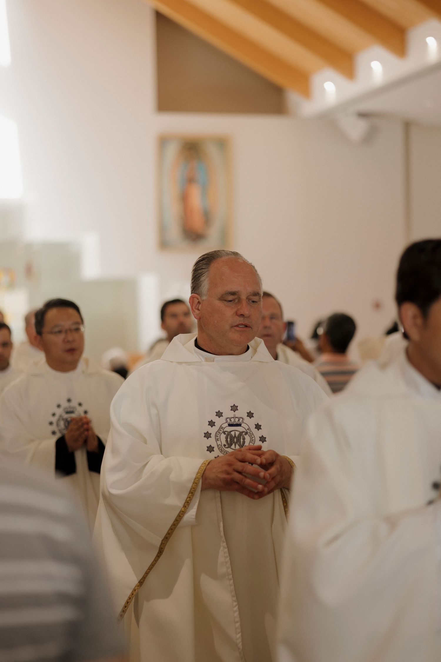 Priests in white vestments gather for a religious ceremony.