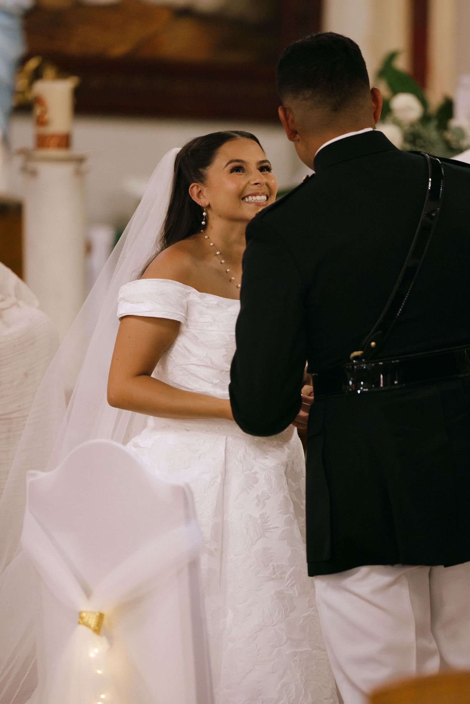 A joyful moment between newlyweds during their military wedding ceremony in church.