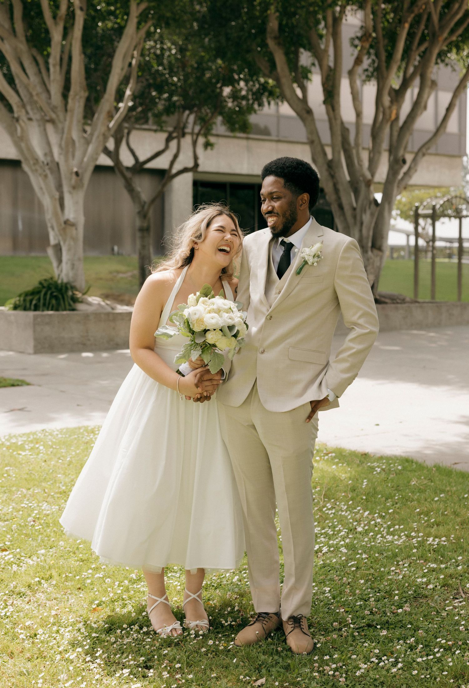 Happy couple shares a candid laughing moment during outdoor wedding photos.