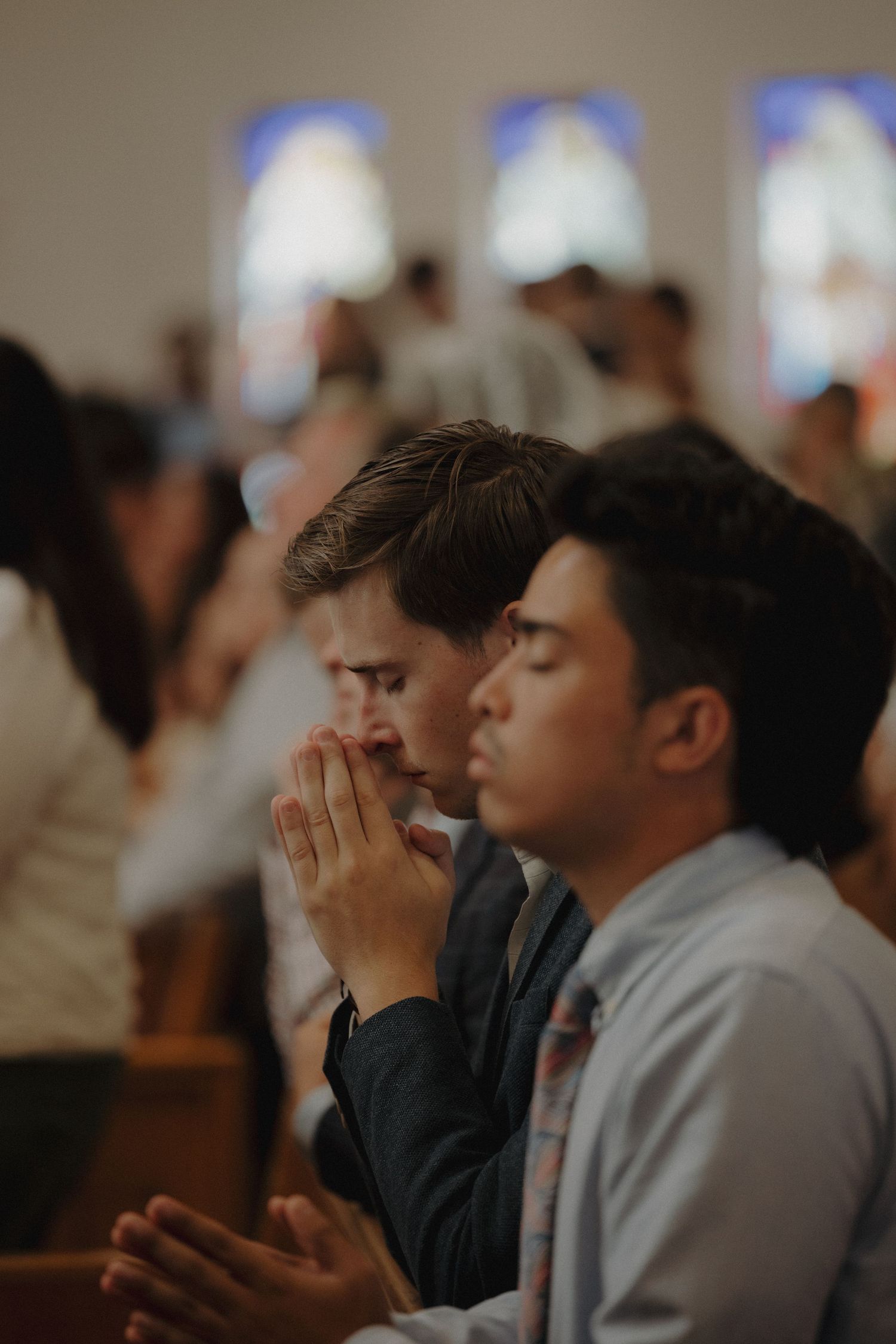Attendees pray with hands clasped during a church service.
