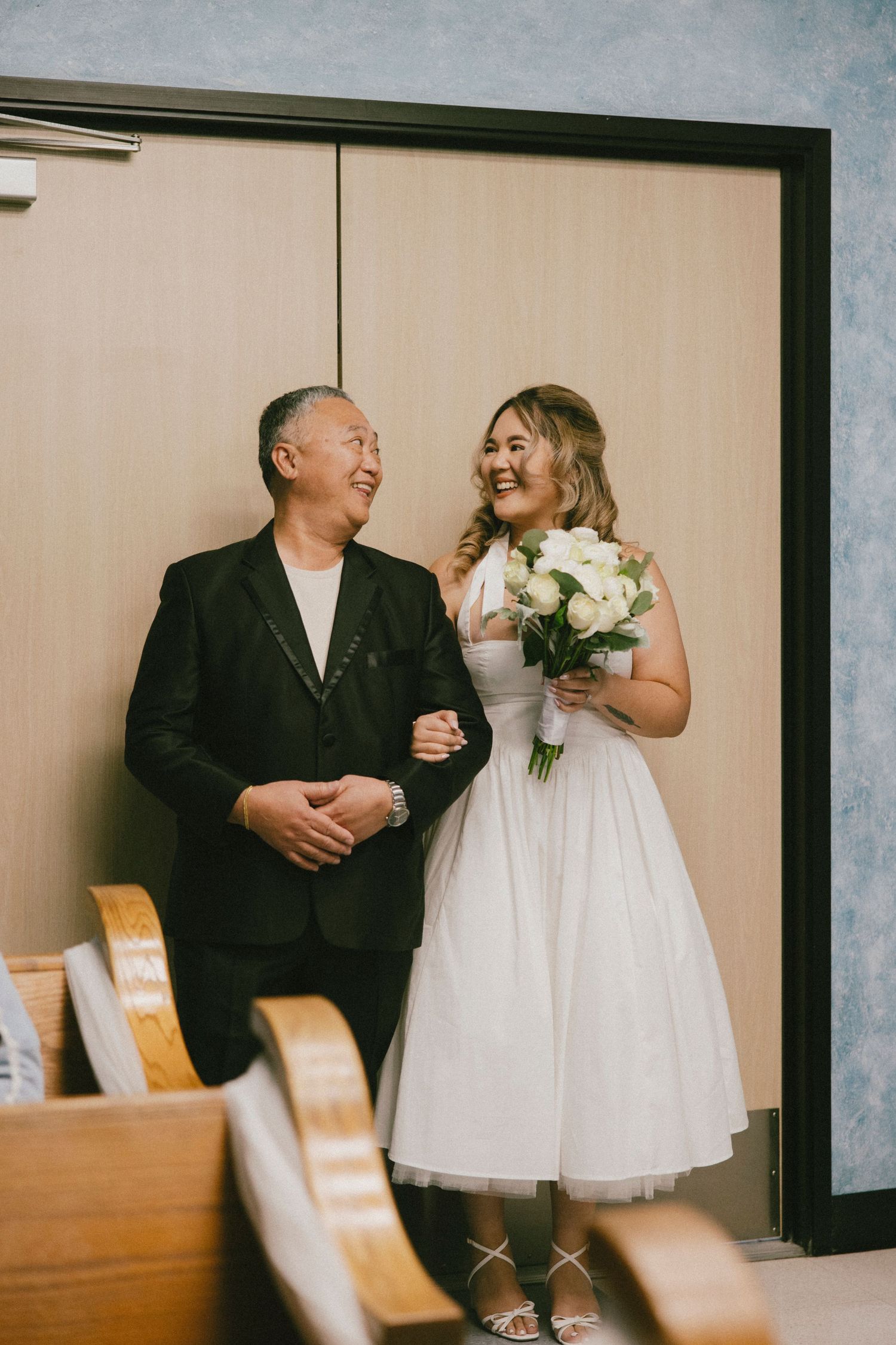 A joyful moment captured between a bride and companion before the ceremony.